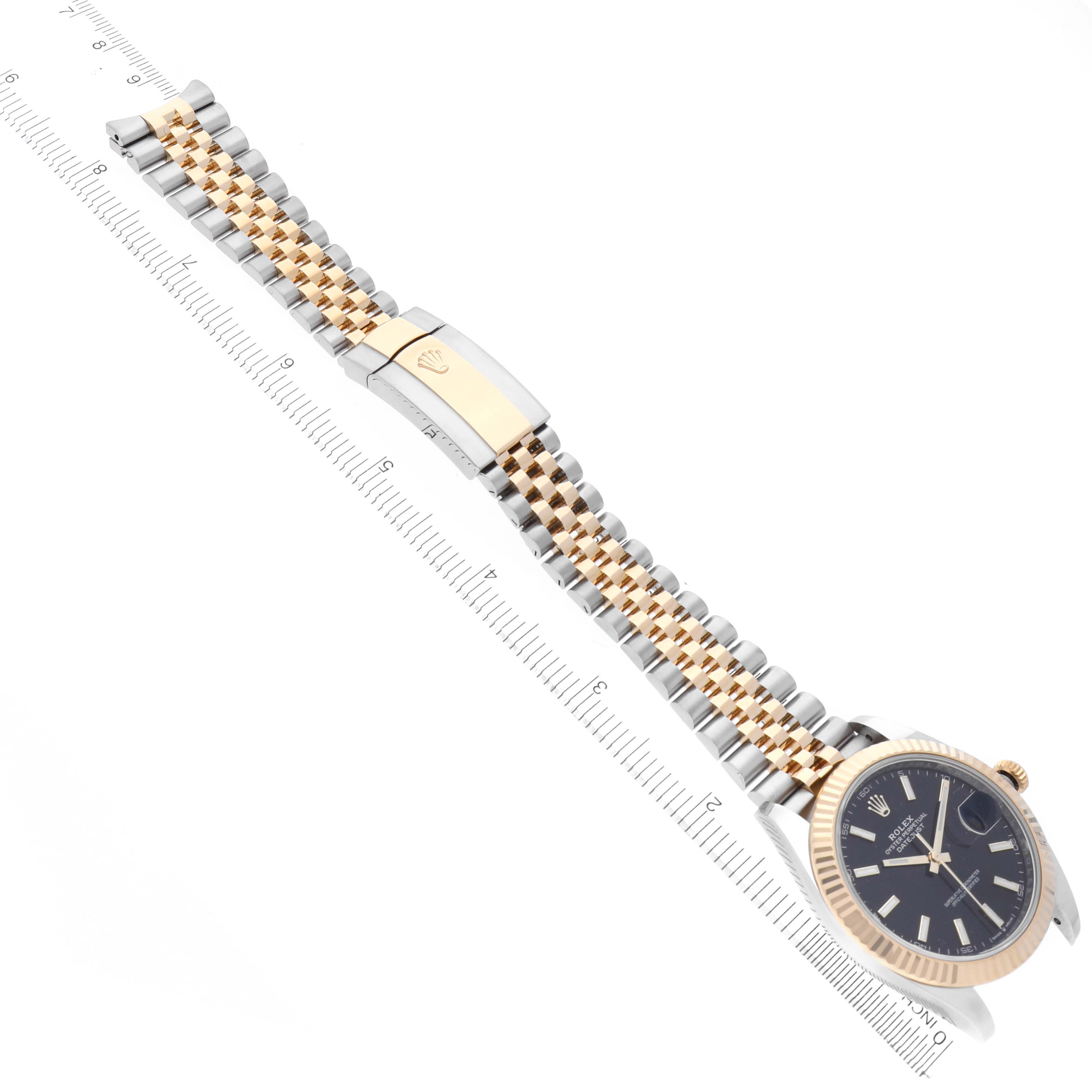 The Rolex Datejust watch is shown at an angle displaying the dial, fluted bezel, and two-tone jubilee bracelet with clasp.