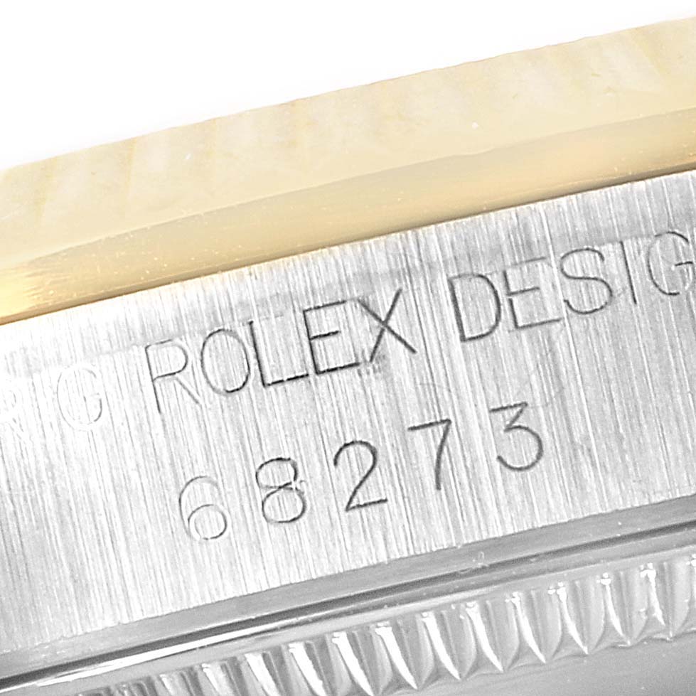 This close-up image shows the model number and the "ROLEX DESIGN" engraving on the side of a Rolex Mid-Size 68273 Women's Steel and Gold (two tone) White Dial 68273 Women's Steel and Gold (two tone) White Dial watch case.