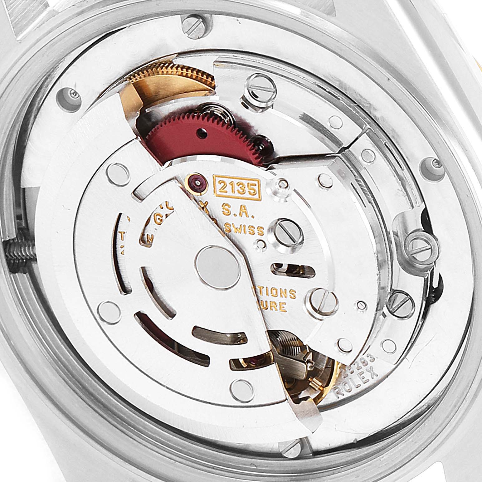 This image shows the inner mechanical movement of a Mid-Size Rolex watch, highlighting the intricate gears and components.