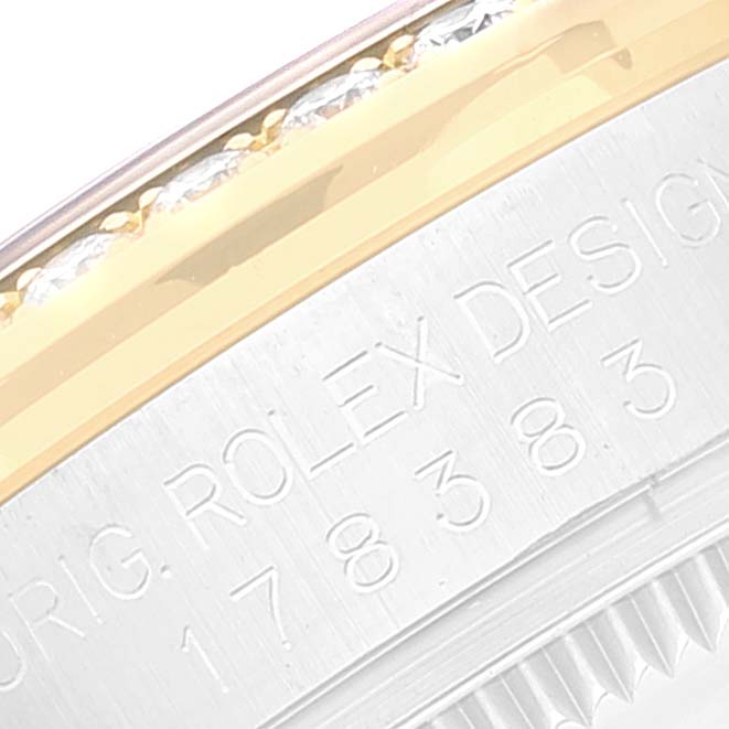 The image shows a close-up angle of the bezel and engraved case-back of a Rolex Mid-Size 178383 Women's Steel and Gold (two tone) Mother of Pearl Dial 178383 Women's Steel and Gold (two tone) Mother of Pearl Dial watch, featuring the text "ROLEX DESIGN."
