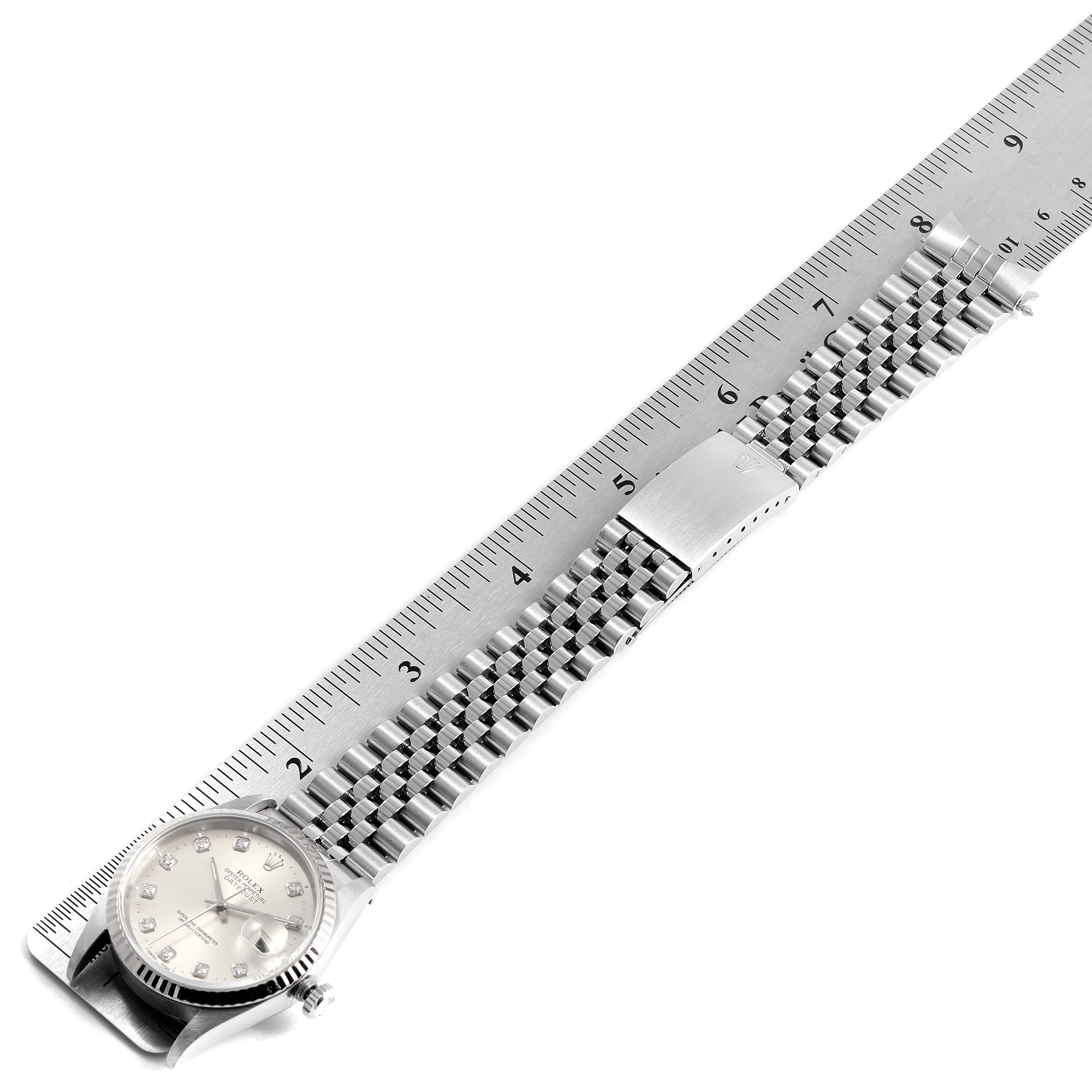 The Rolex Datejust 16234 Men's Stainless Steel Silver Dial 16234 Men's Stainless Steel Silver Dial watch is shown from a top-down angle, featuring its face, bracelet, and clasp next to a ruler for scale.