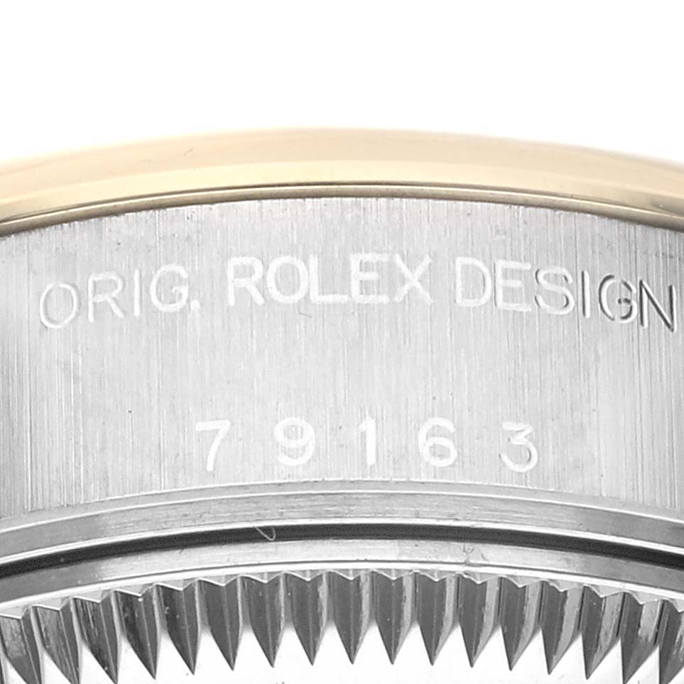 The image shows the side engraving with serial number on the Rolex Datejust 79163 Women's Steel and Gold (two tone) Black Dial 79163 Women's Steel and Gold (two tone) Black Dial bezel and case.