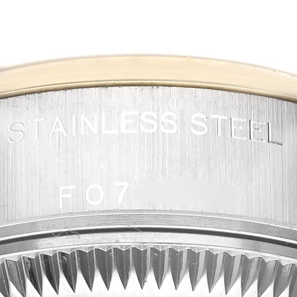 The image shows a close-up of the Rolex Datejust 79163 Women's Steel and Gold (two tone) Black Dial 79163 Women's Steel and Gold (two tone) Black Dial's fluted bezel and "Stainless Steel" marking.