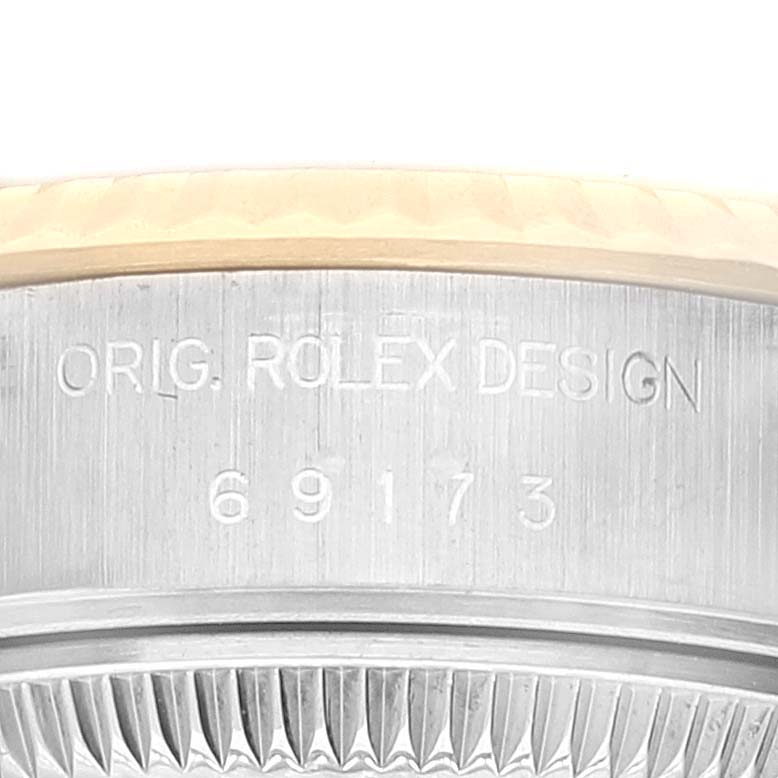 This image shows an engraved side view of a Rolex Datejust 69173 Women's Steel and Gold (two tone) White Dial 69173 Women's Steel and Gold (two tone) White Dial model, displaying the serial number and bezel detail.