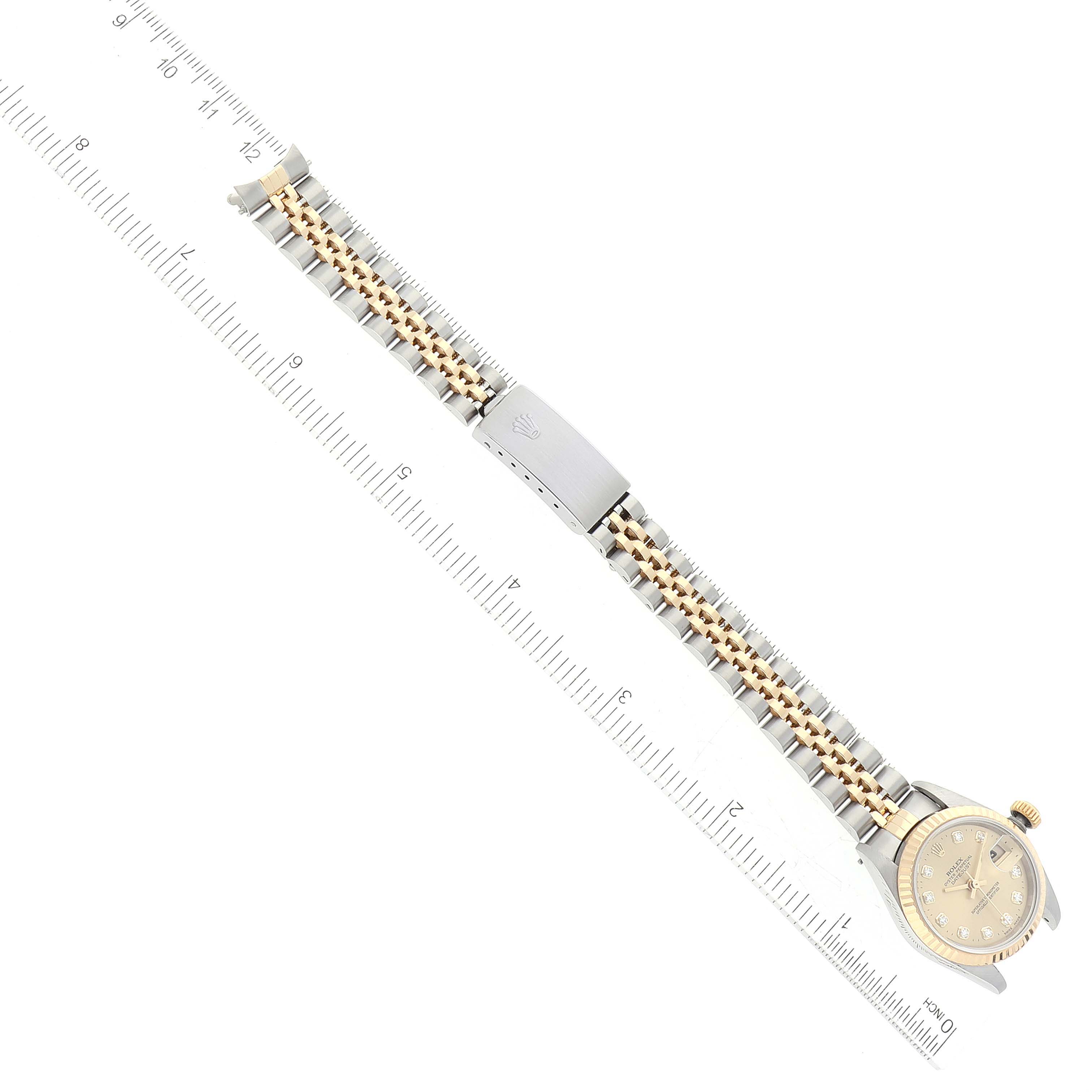 The image shows a Rolex Datejust 79173 Women's Steel and Gold (two tone) Champagne Dial 79173 Women's Steel and Gold (two tone) Champagne Dial watch laid flat with the dial, crown, bracelet, and clasp visible next to a ruler for scale.