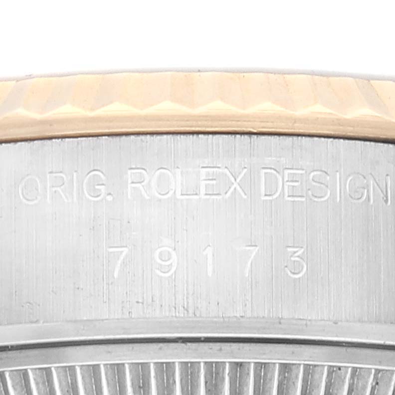 This image shows a close-up of the case side of a Rolex Datejust 79173 Women's Steel and Gold (two tone) Champagne Dial 79173 Women's Steel and Gold (two tone) Champagne Dial model, displaying the engraved model number and "Orig. Rolex Design".