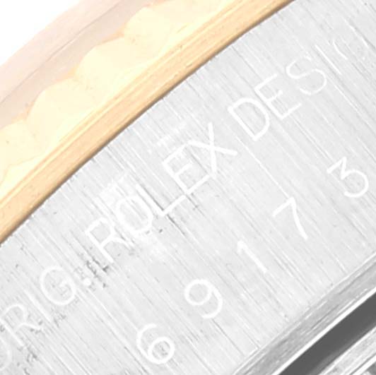 This close-up shows the edge of the case and bezel of a Rolex Datejust 69173 Women's Steel and Gold (two tone) White Dial 69173 Women's Steel and Gold (two tone) White Dial watch, highlighting the engraved Rolex design.