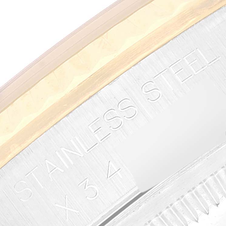 This is a close-up image of the edge of the stainless steel case of a Rolex Datejust 16233 Men's Steel and Gold (two tone) Beige Dial 16233 Men's Steel and Gold (two tone) Beige Dial watch, showing part of the engraving.