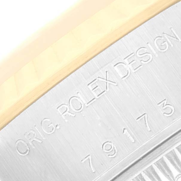 The image shows a close-up of the engraved serial number and "ORIG. ROLEX DESIGN" on a Rolex Datejust 79173 Women
s Steel and Gold (two tone) Red Dial 79173 Women
s Steel and Gold (two tone) Red Dial watch case.