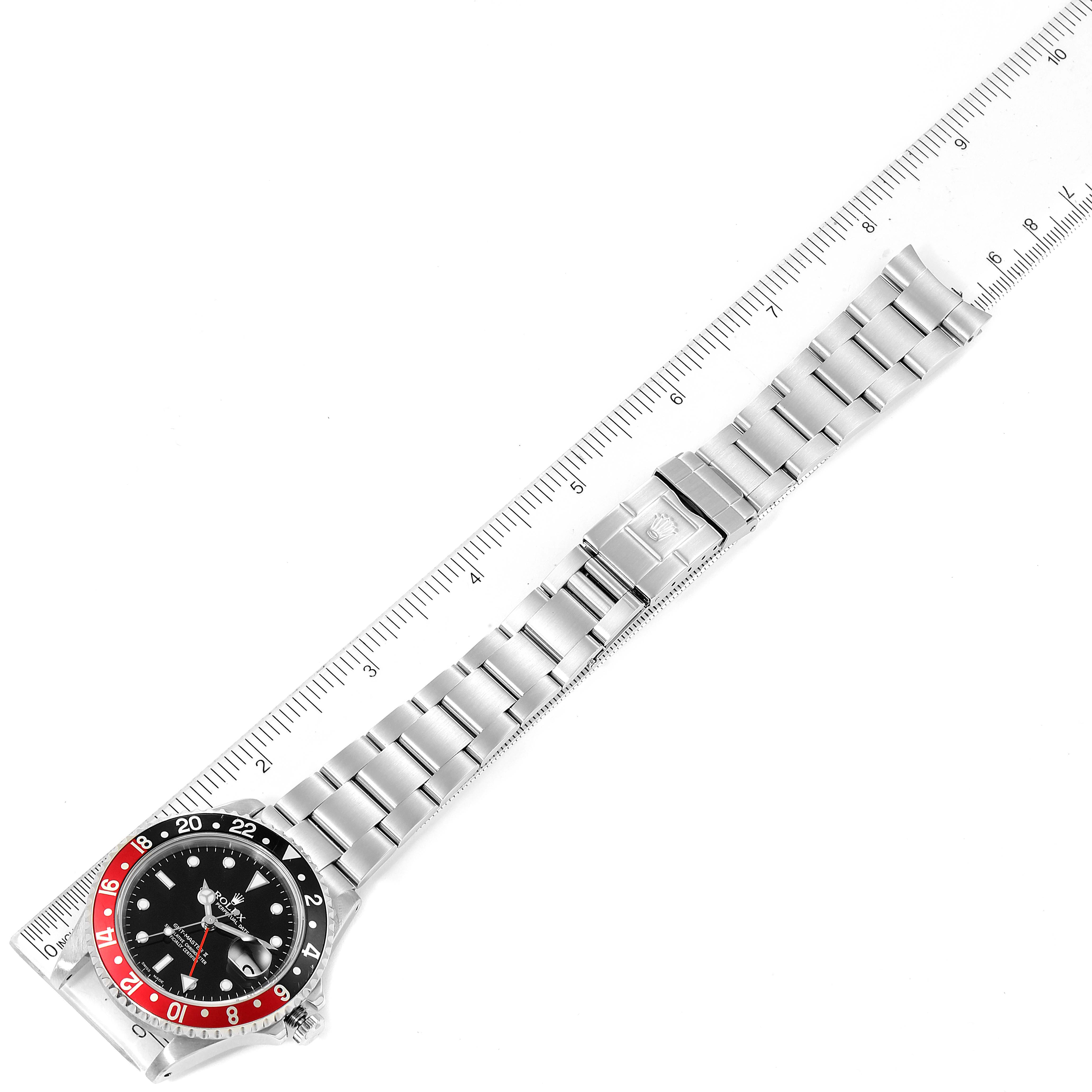 The image shows a top-down view of a Rolex GMT-Master 16710 Men
s Stainless Steel Black Dial 16710 Men
s Stainless Steel Black Dial watch, highlighting its bezel, dial, and entire bracelet alongside a ruler.