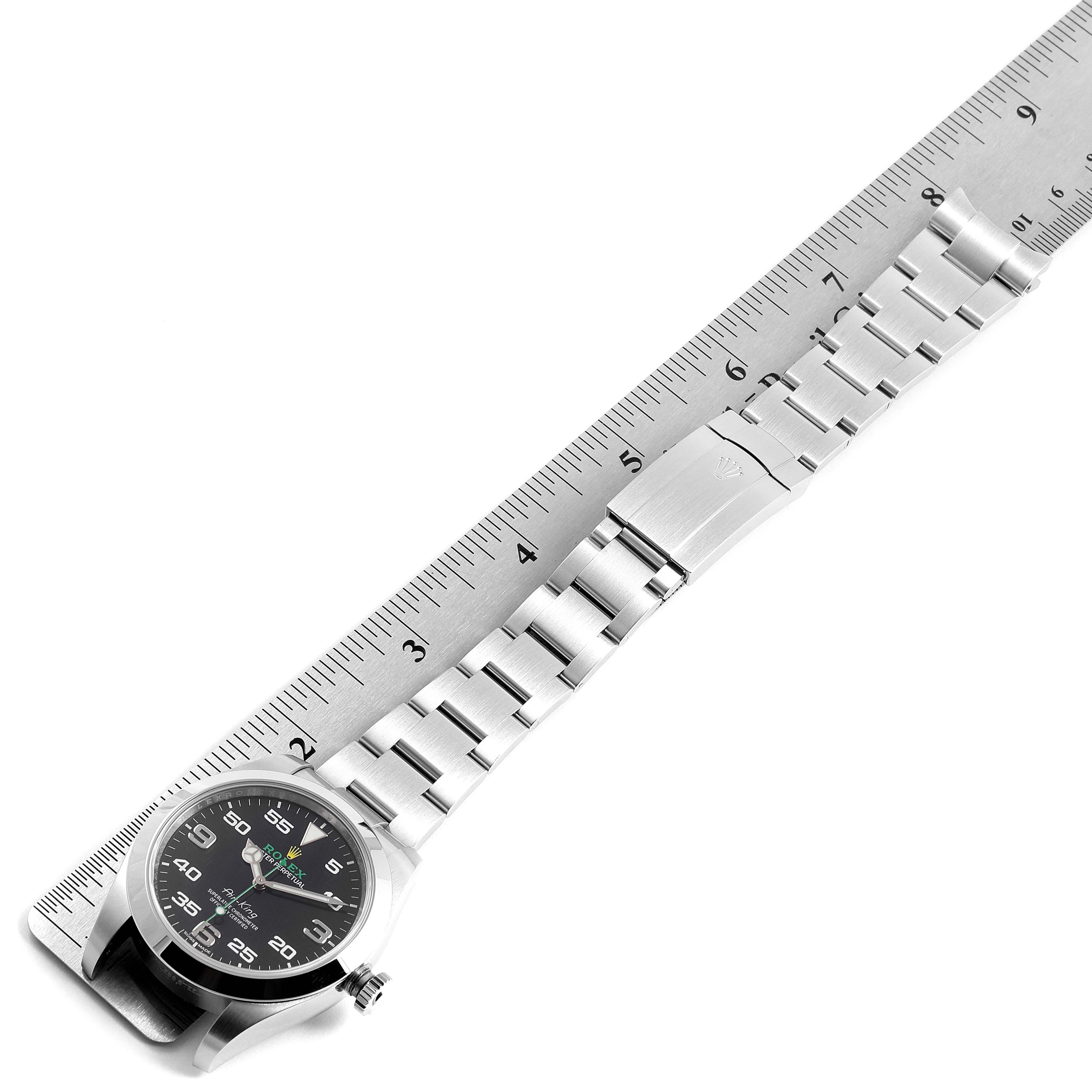 This image shows a Rolex Air-King 116900 Men's Stainless Steel Black Dial 116900 Men's Stainless Steel Black Dial watch laid flat next to a ruler, highlighting its stainless steel bracelet and black dial.