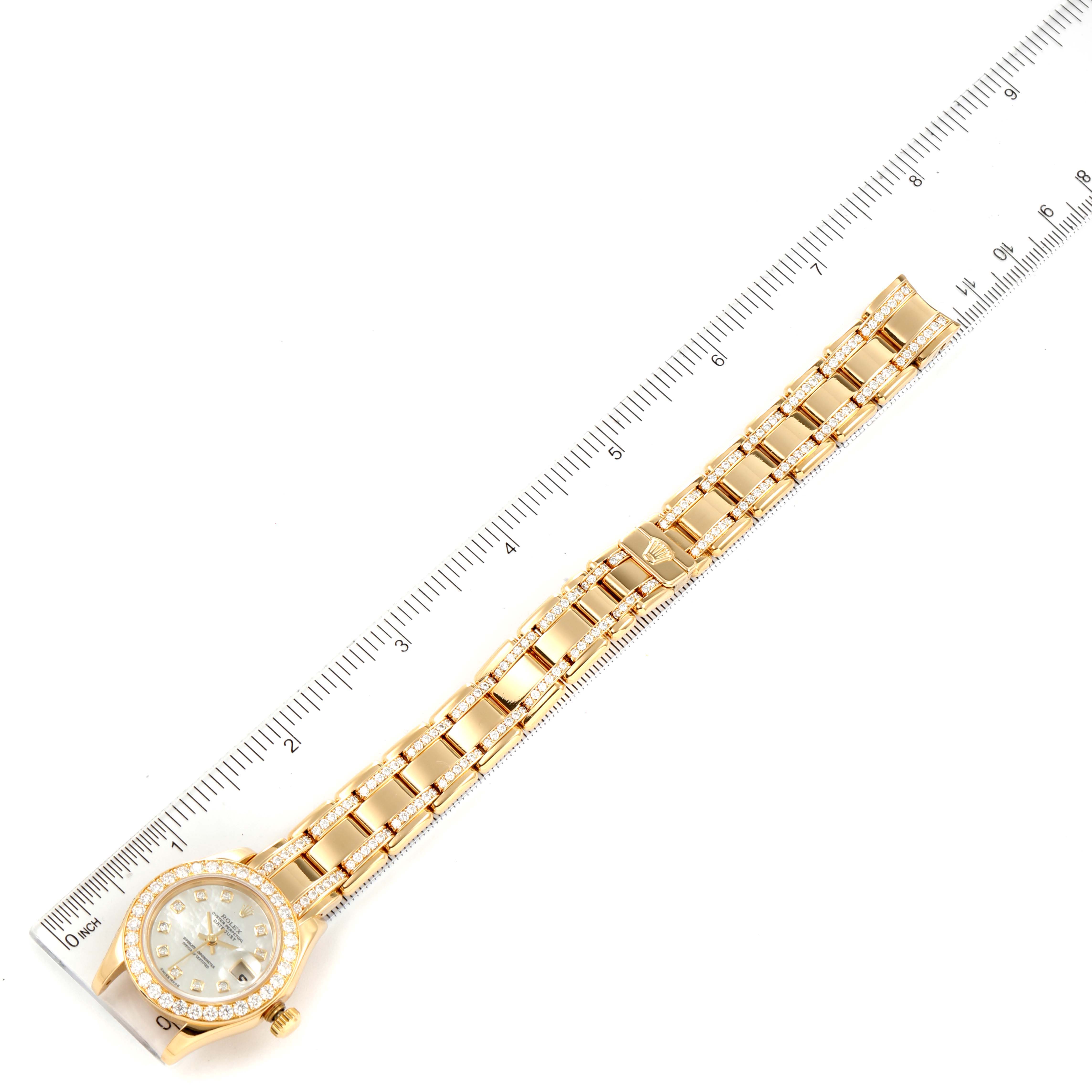 The Rolex Pearlmaster 80298 Women's Yellow Gold Mother of Pearl Dial 80298 Women's Yellow Gold Mother of Pearl Dial watch is shown laid flat with the face, bezel, bracelet, and clasp in view alongside a ruler for measurement.
