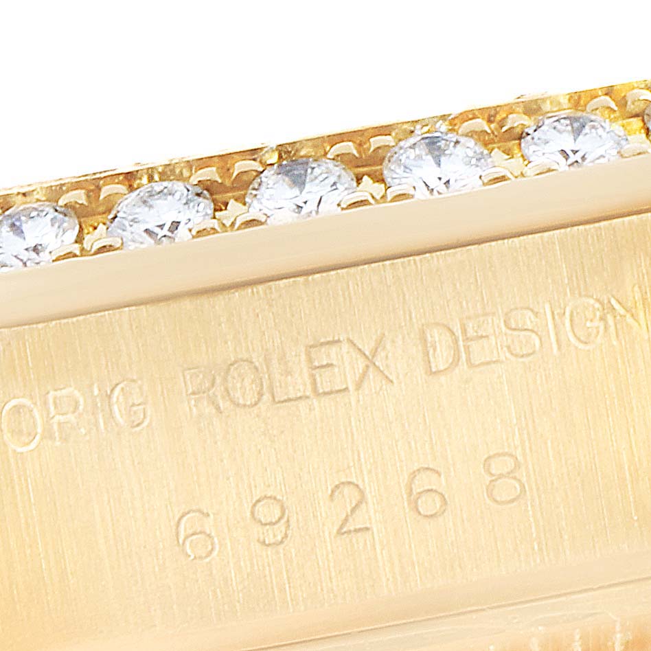 This close-up image shows the edge of a Rolex President 69268 Women
s Yellow Gold Champagne Dial 69268 Women
s Yellow Gold Champagne Dial model watch case with diamonds and the model number engraved.