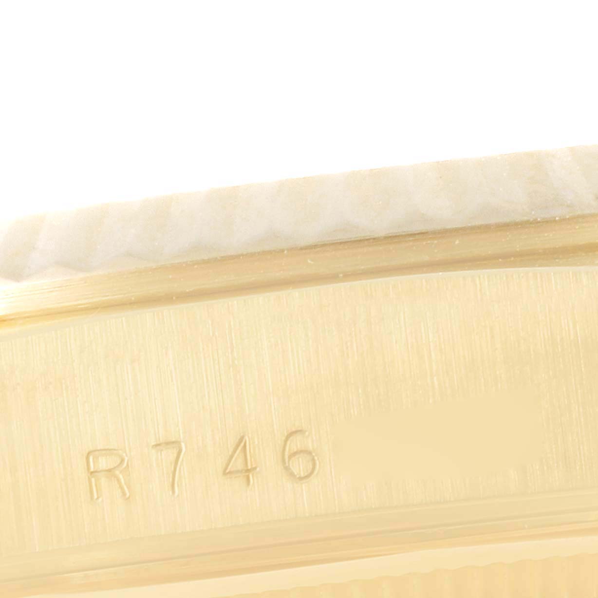 This close-up image shows the side of a Rolex President 18238 Men
s Yellow Gold Champagne Dial 18238 Men
s Yellow Gold Champagne Dial model watch, focusing on the serial number engraved on the case.