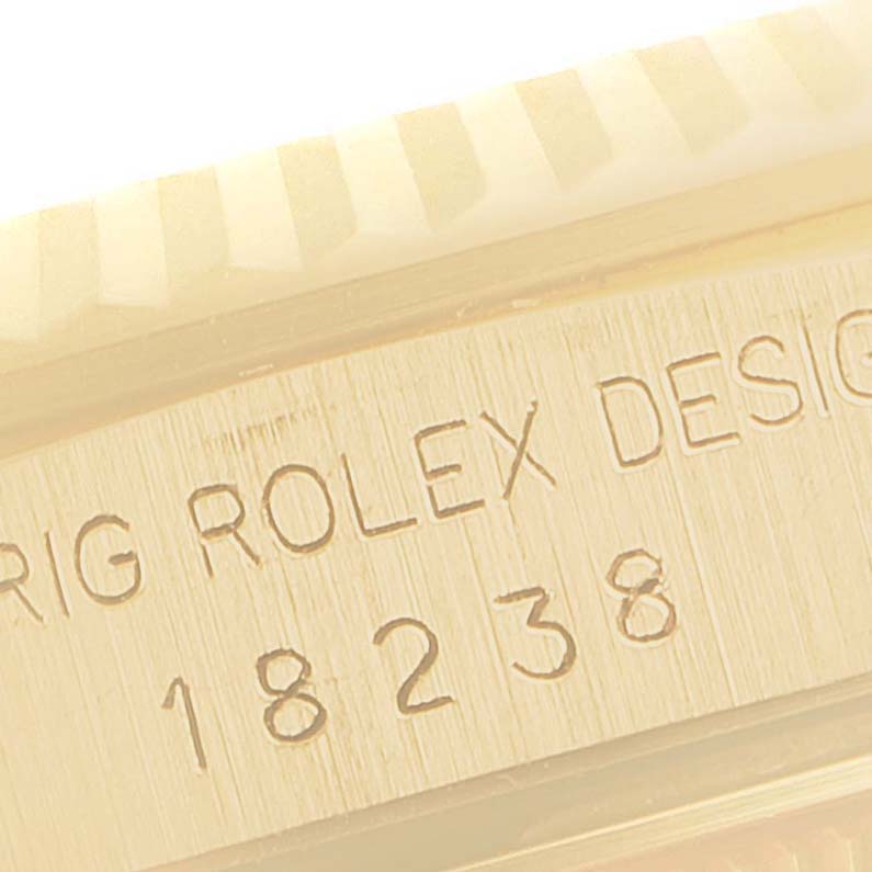 This image shows a close-up of the side of a Rolex President 18238 Men
s Yellow Gold Champagne Dial 18238 Men
s Yellow Gold Champagne Dial model 18238, highlighting the engraved serial number and part of the bezel.