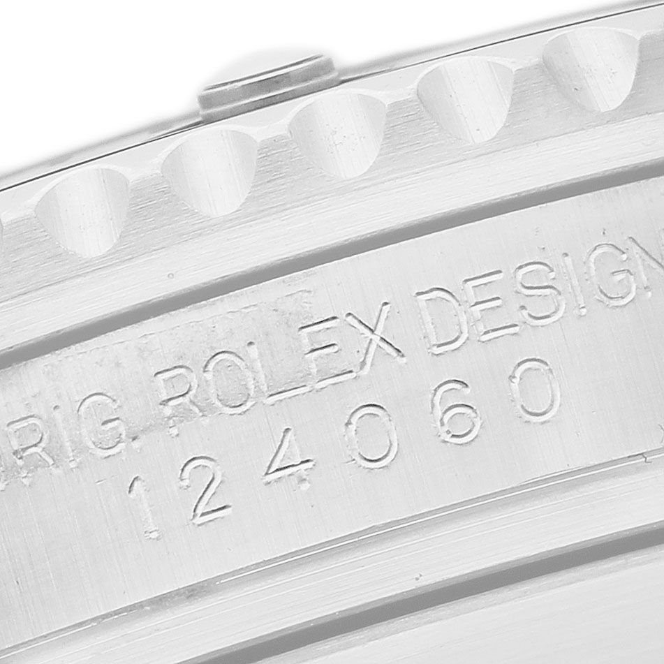 The image shows a close-up of the engraved serial number and bezel edge of a Rolex Submariner 124060 Men's Stainless Steel Black Dial watch.