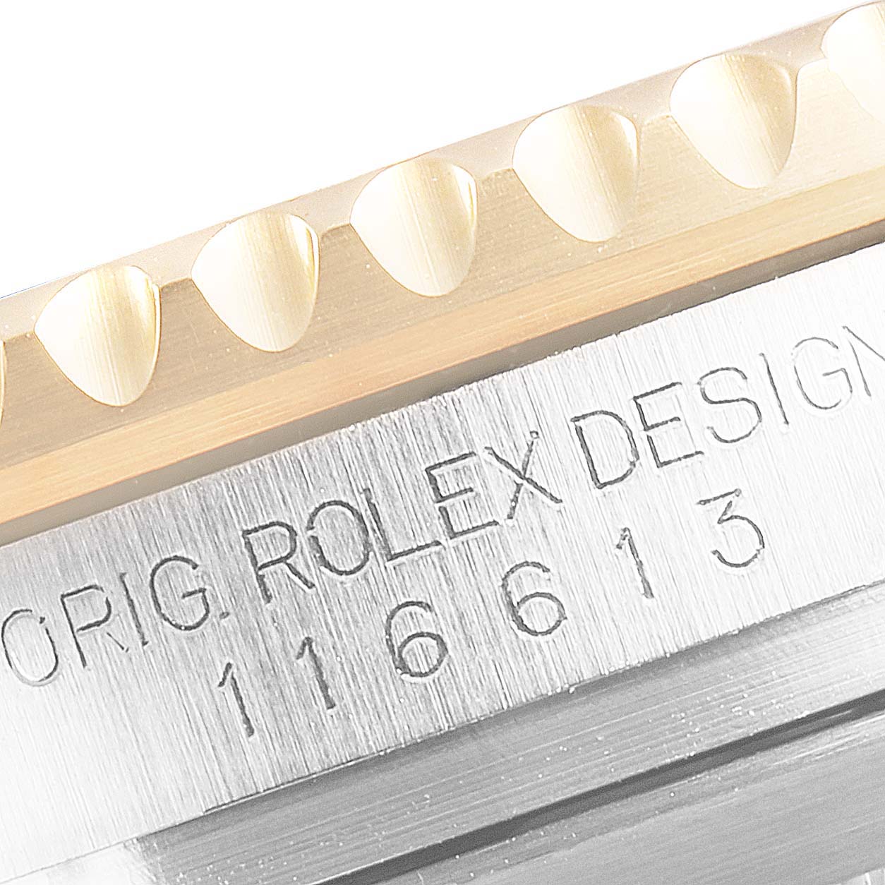The image shows a close-up of the engraved serial number and bezel of a Rolex Submariner 116613 Men's Steel and Gold (two tone) Blue Dial 116613 Men's Steel and Gold (two tone) Blue Dial watch.
