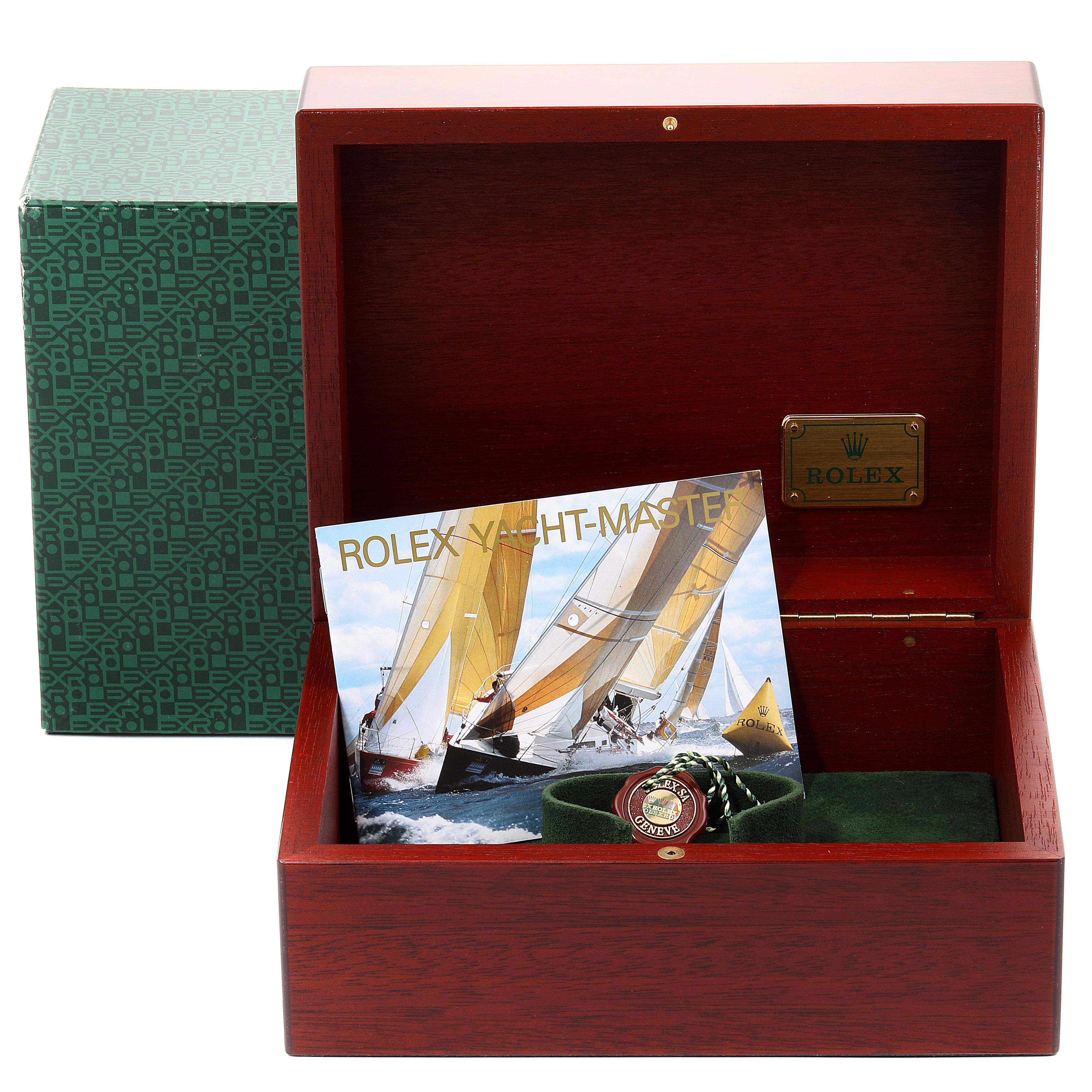 This image shows the Rolex Yacht-Master 16628B Men's Yellow Gold White Dial 16628B Men's Yellow Gold White Dial watch box, with the outer green box, booklet, and a green accessory pouch inside.