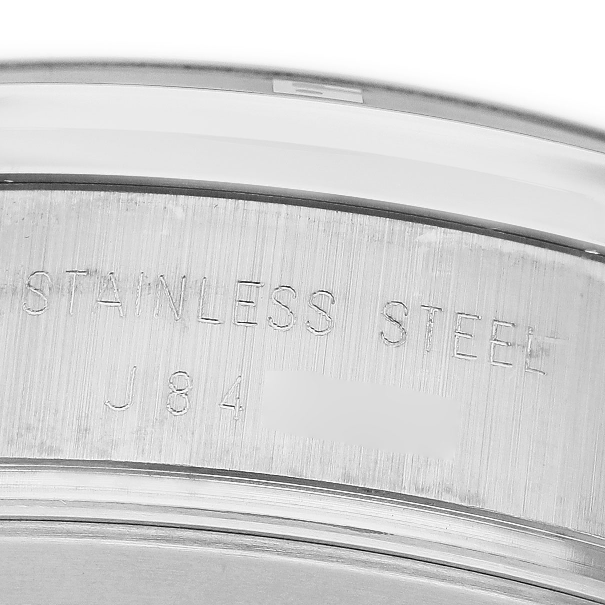 The image shows a close-up of the side of the case back of a Tudor Glamour 20550N-95730 Men's Stainless Steel White Dial watch with "stainless steel" engraved.
