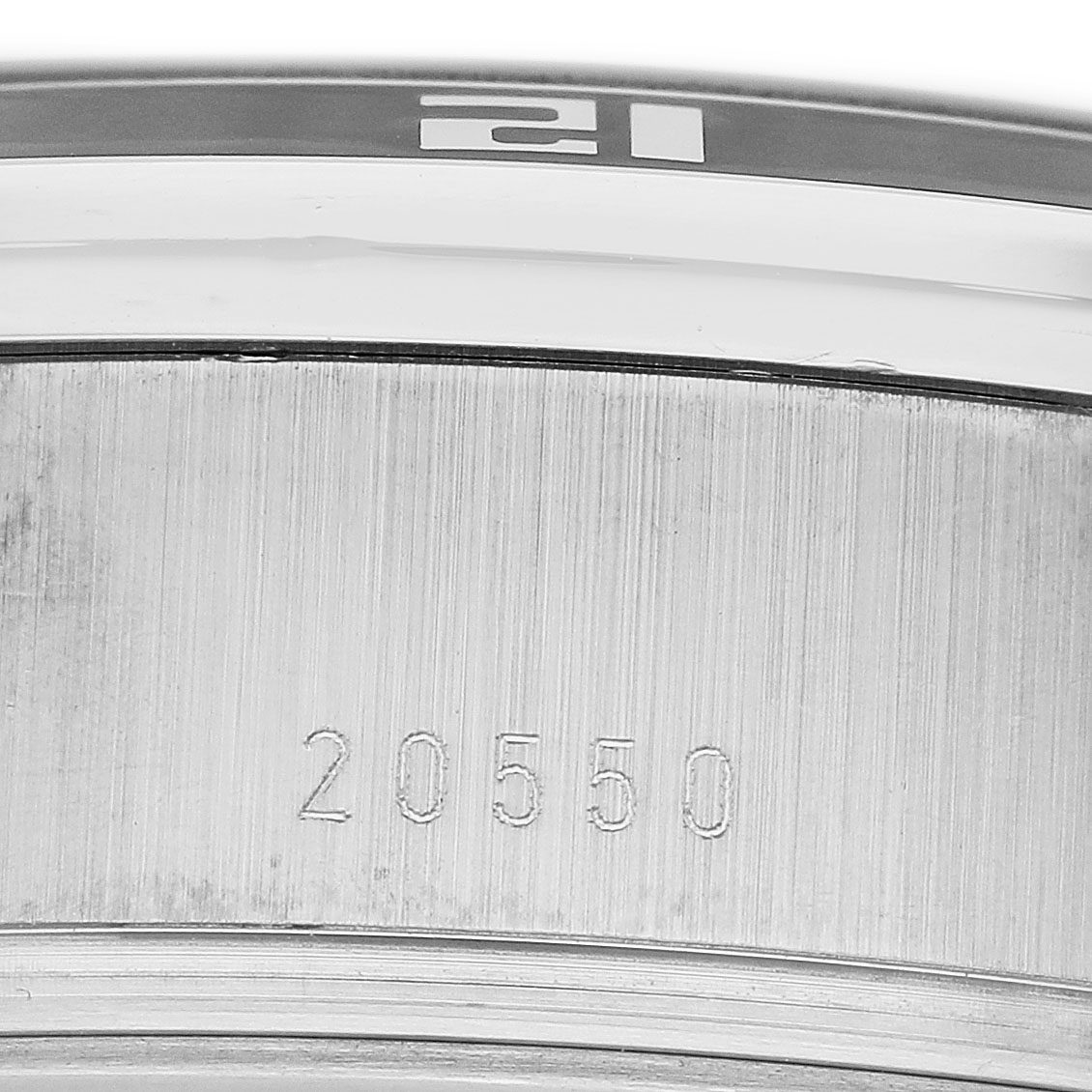 The image shows a close-up of the case side and engraved numbers of the Tudor Glamour 20550N-95730 Men's Stainless Steel White Dial watch model.
