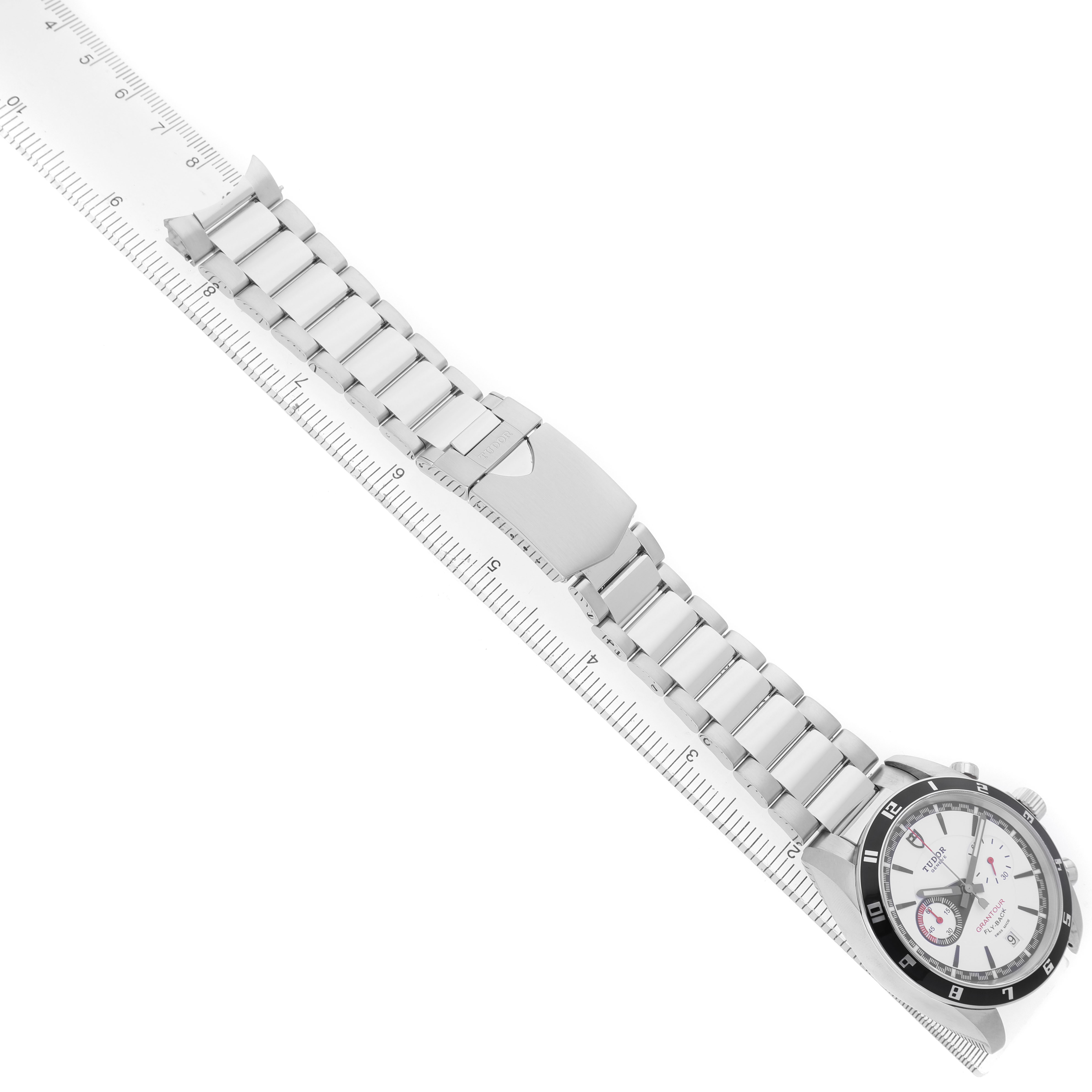 The Tudor Glamour 20550N-95730 Men's Stainless Steel White Dial watch is shown from a top-down angle, displaying its face and stainless steel bracelet with a clasp.