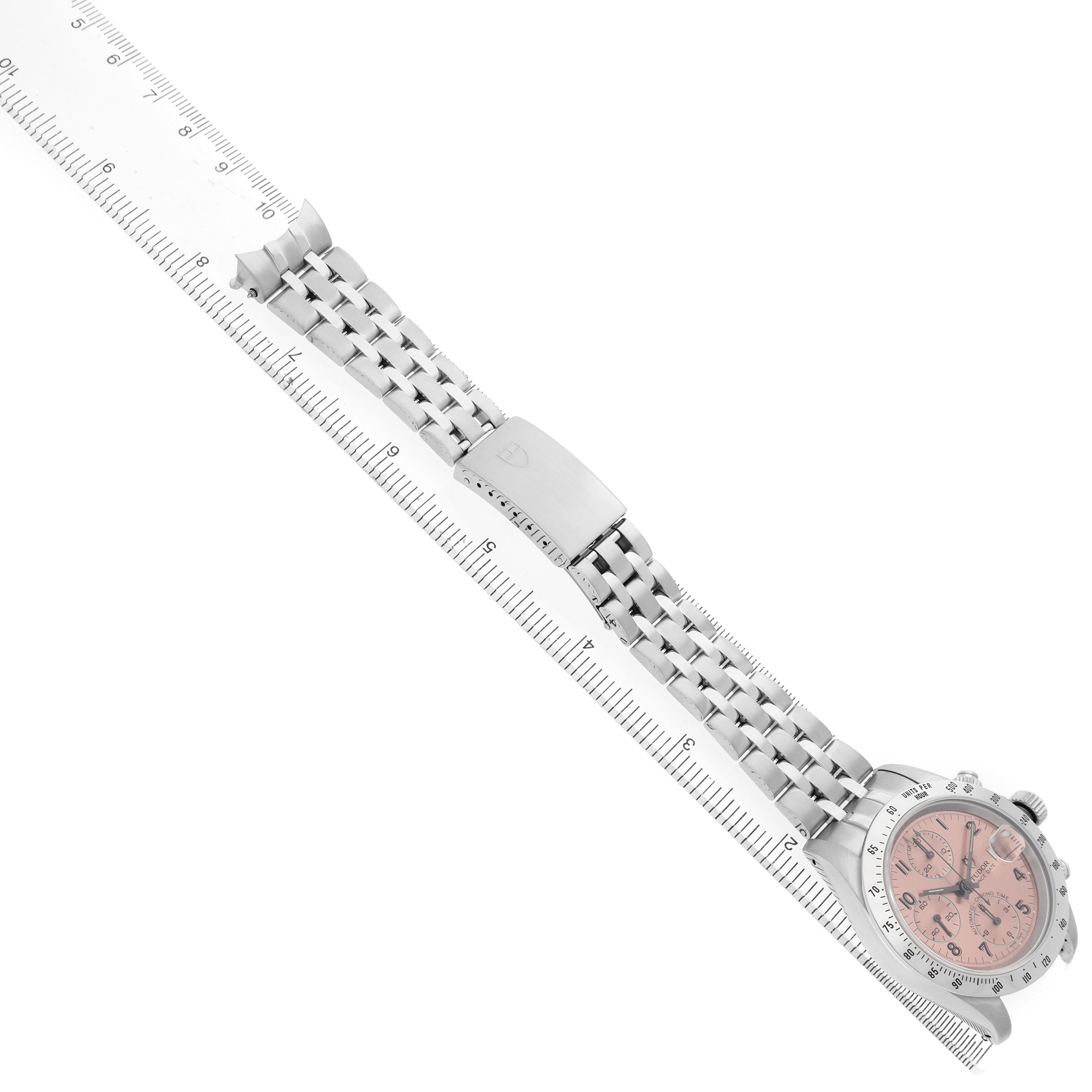 The Tudor Prince 79280 Men's Stainless Steel Pink Dial watch is shown at an angle, displaying the face, bracelet, and clasp alongside a ruler for scale.