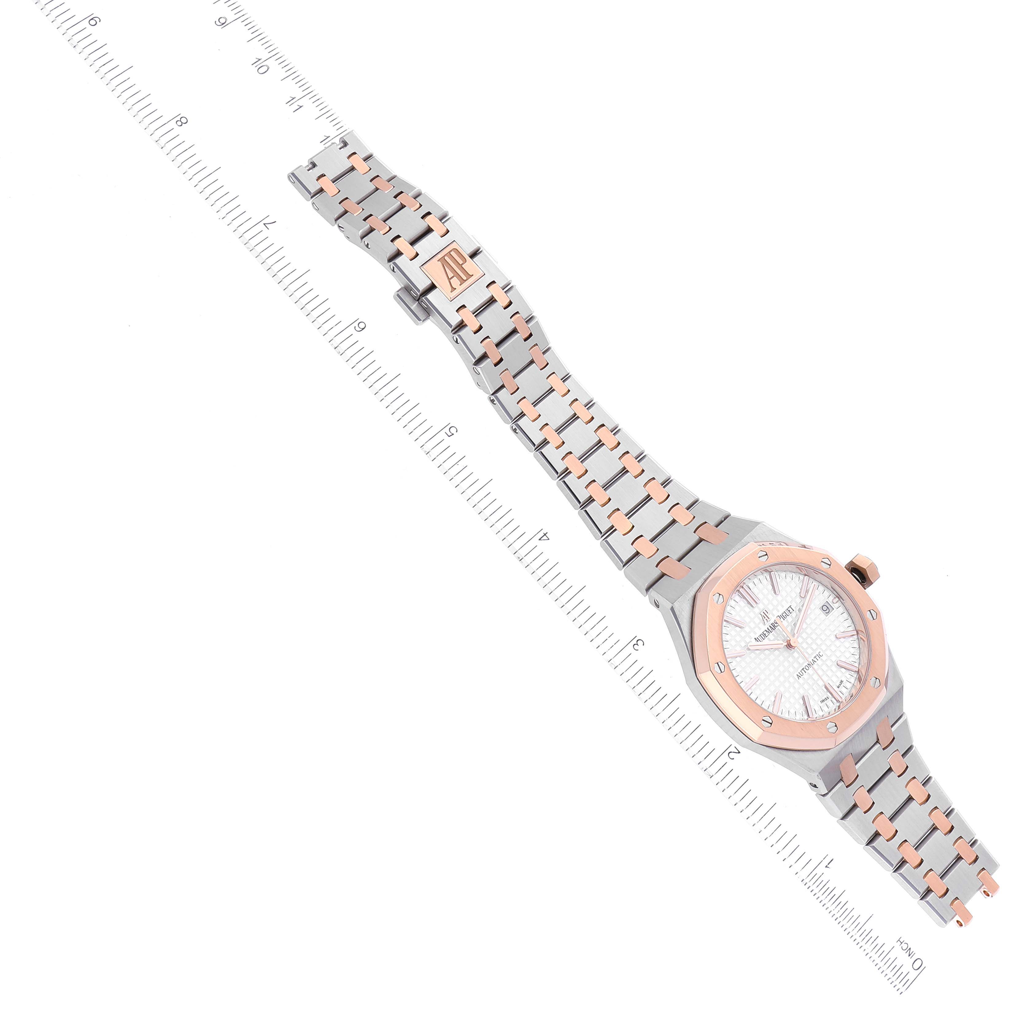 The image shows an overhead view of an Audemars Piguet Royal Oak 15450SR.OO.1256SR.01 Men's Steel and Gold (two tone) Silver Dial 15450SR.OO.1256SR.01 Men's Steel and Gold (two tone) Silver Dial watch with a ruler for scale.