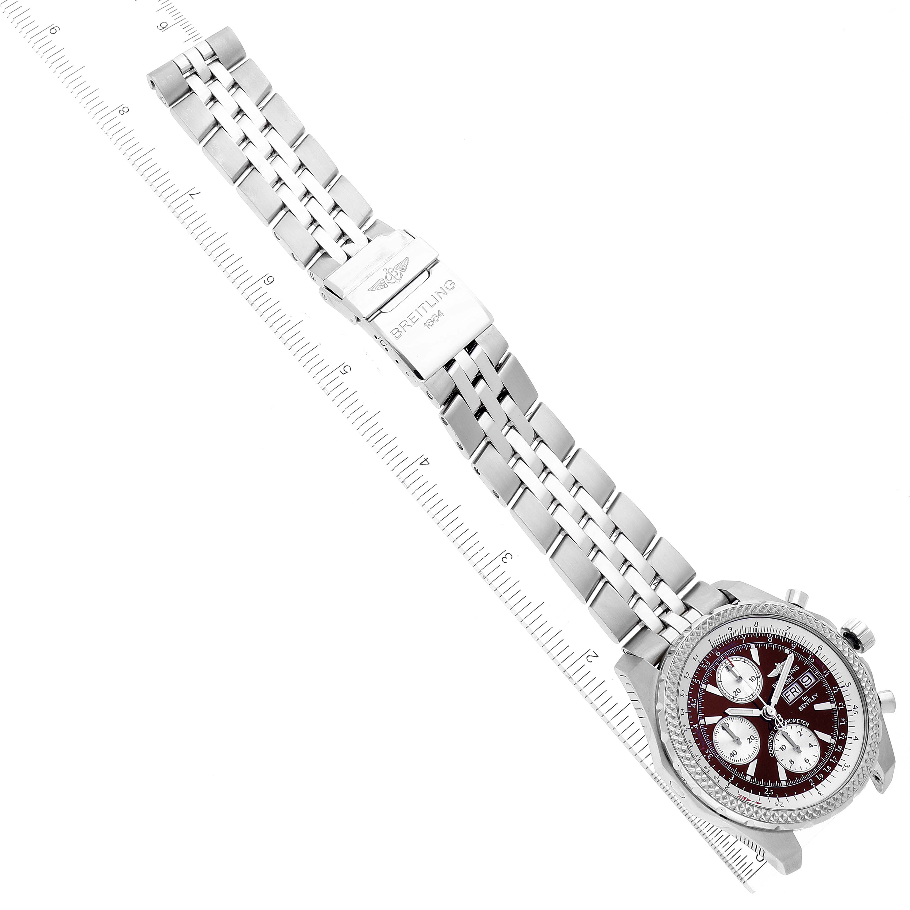 The image shows a top-down view of a Breitling Bentley A13363 Men's Stainless Steel Burgundy Dial A13363 Men's Stainless Steel Burgundy Dial watch, highlighting its dial, bracelet, and clasp alongside a ruler.