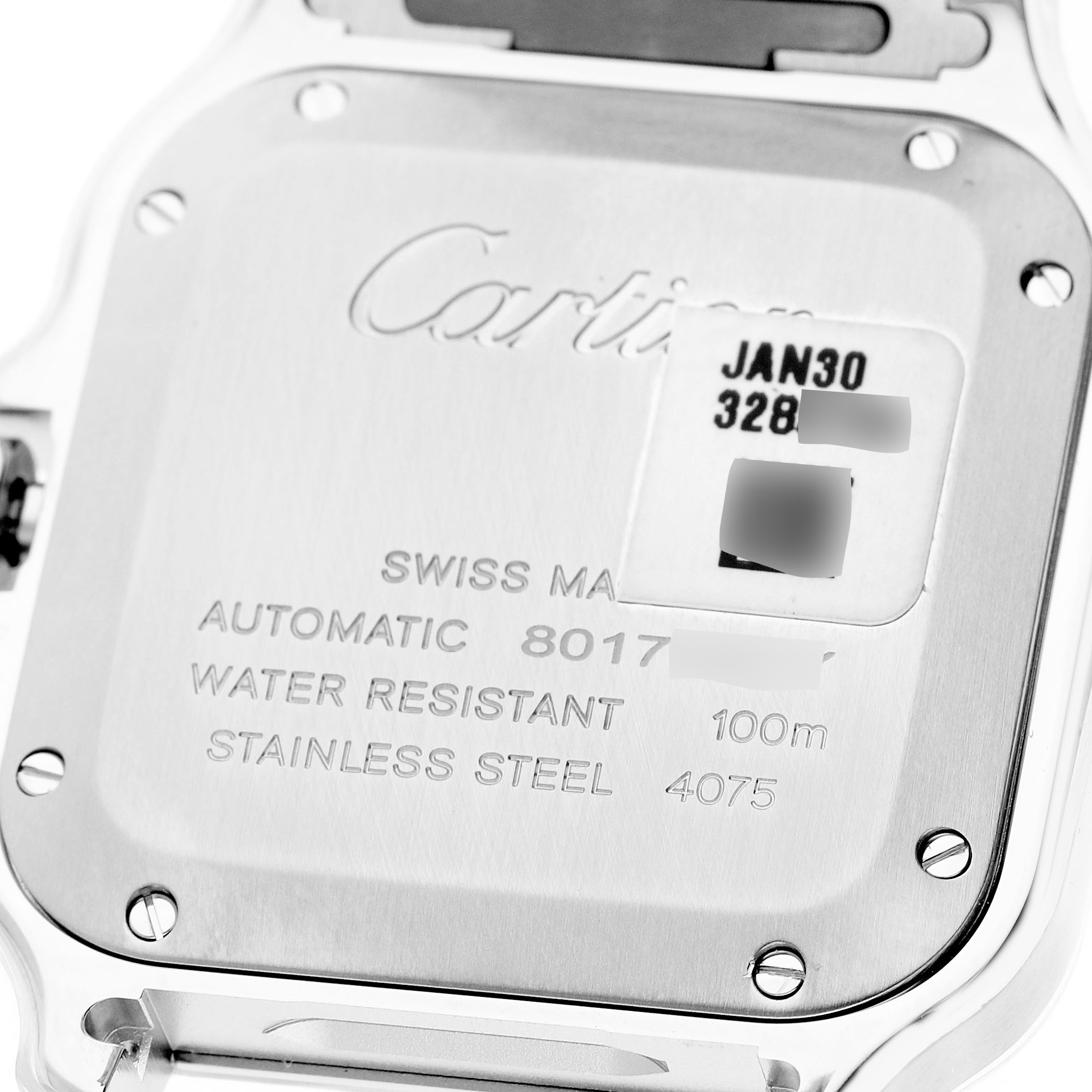 The image shows the back case of a Cartier Santos WSSA0029 Men's Stainless Steel Silver Dial model, displaying engraving details and screws.
