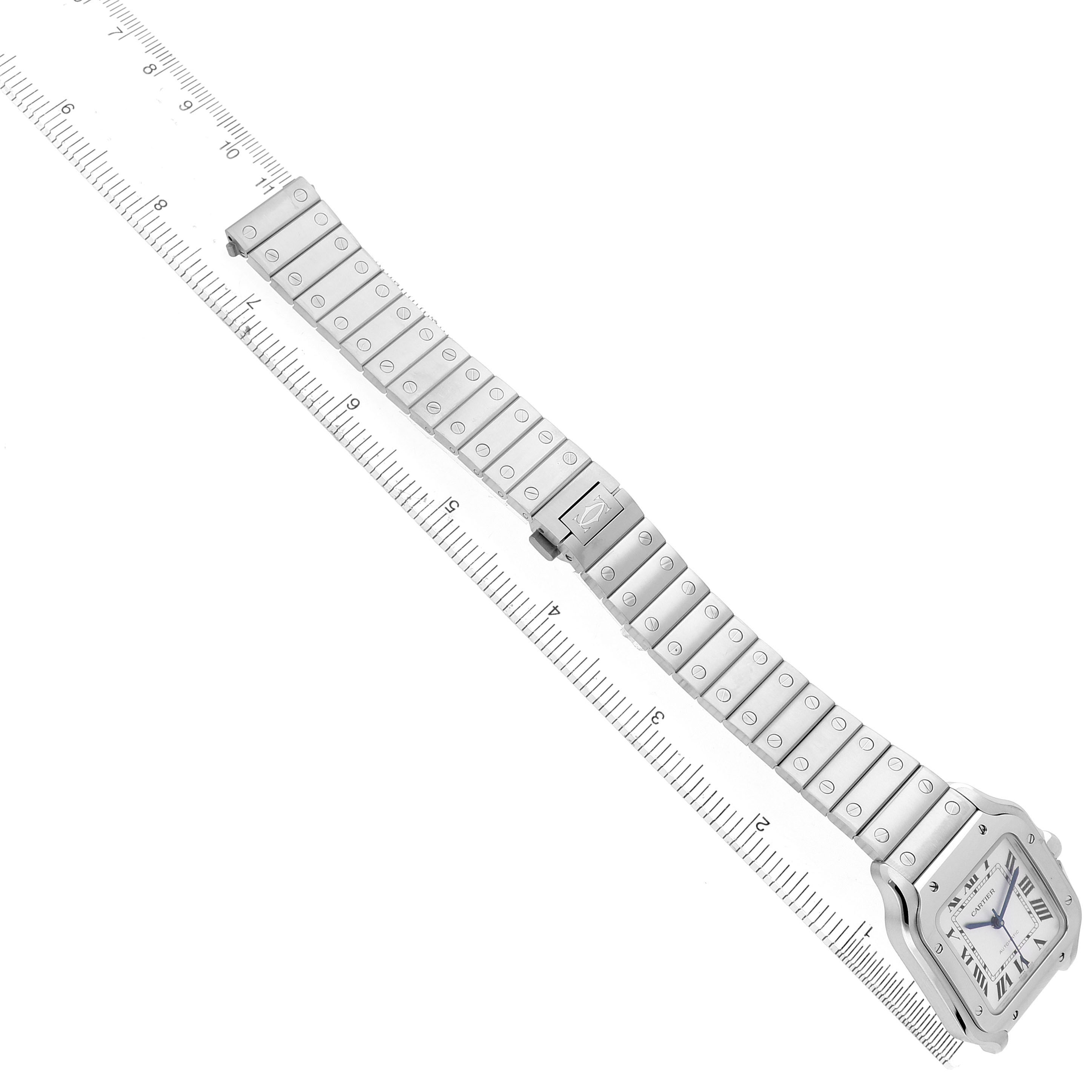 The Cartier Santos WSSA0029 Men's Stainless Steel Silver Dial watch is shown at a diagonal angle, displaying its full bracelet and square face with Roman numerals.
