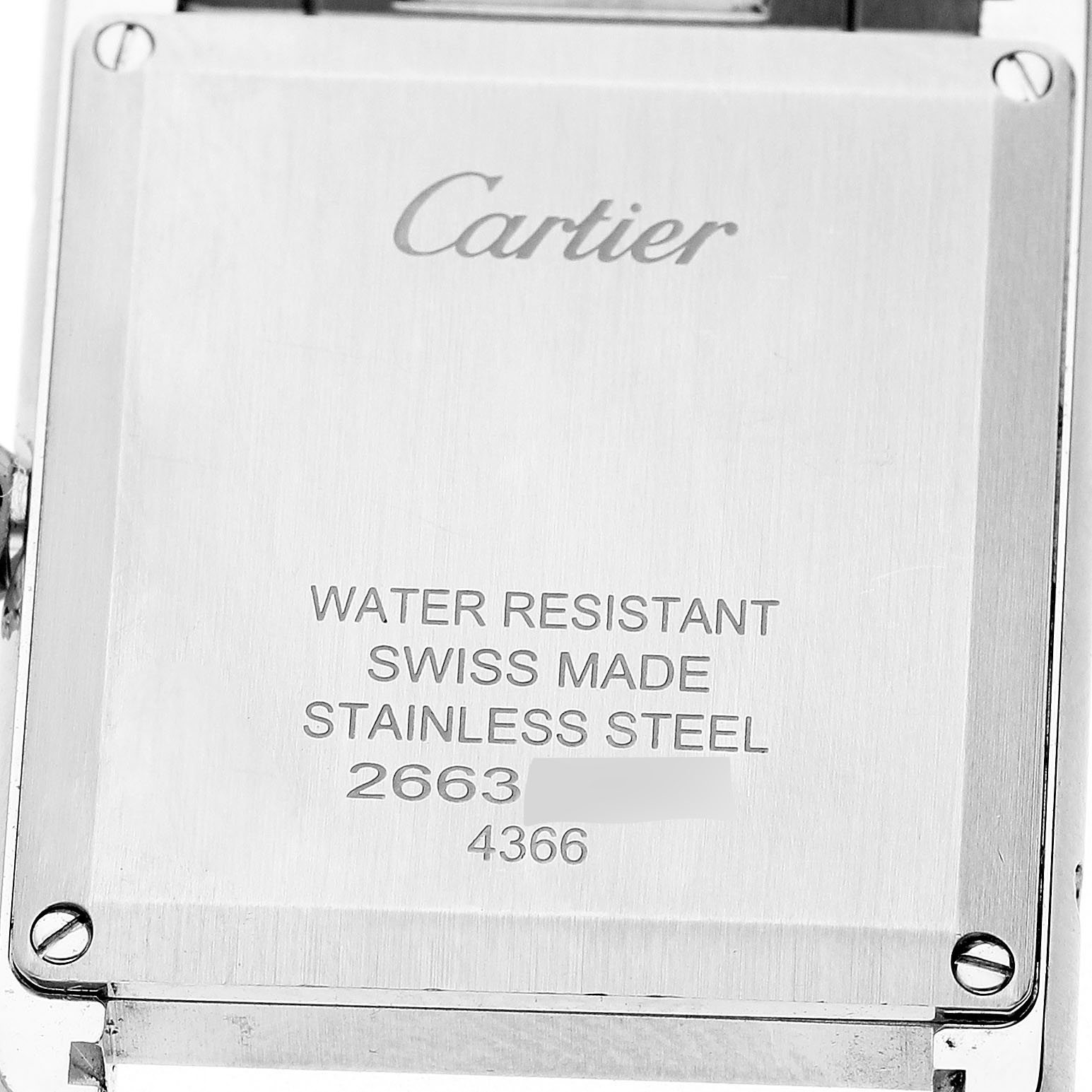The image shows the back of a Cartier Tank Must WSTA0062 Women's Stainless Steel Silver Dial watch, displaying engravings about material and water resistance.