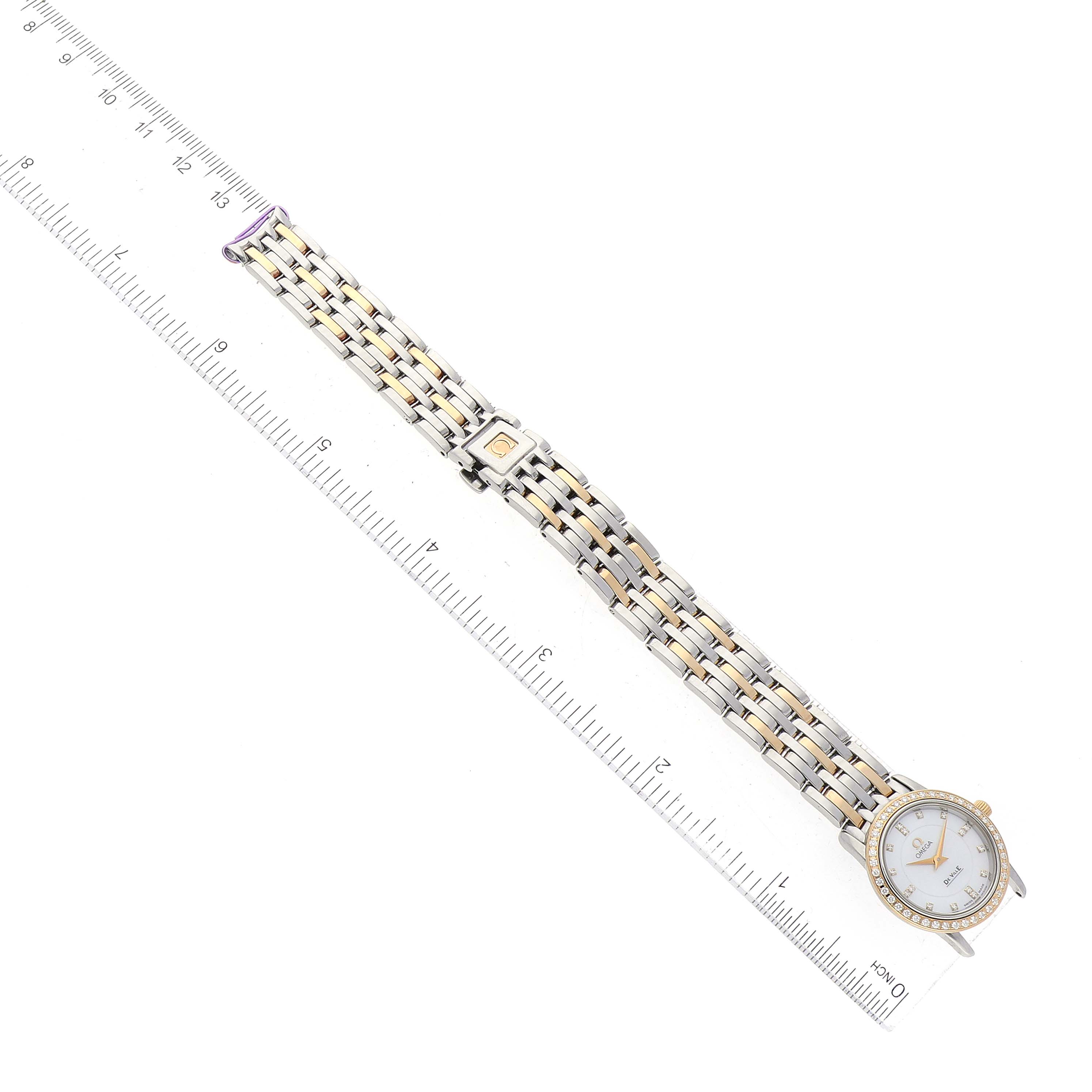 This image shows the Omega 4375.75.00 Women's Stainless Steel Mother of Pearl Dial 4375.75.00 Women's Stainless Steel Mother of Pearl Dial DeVille Mother Of Pearl Diamond Steel Yellow Gold Ladies Watch (model 4375.75.00) laid flat alongside a ruler.