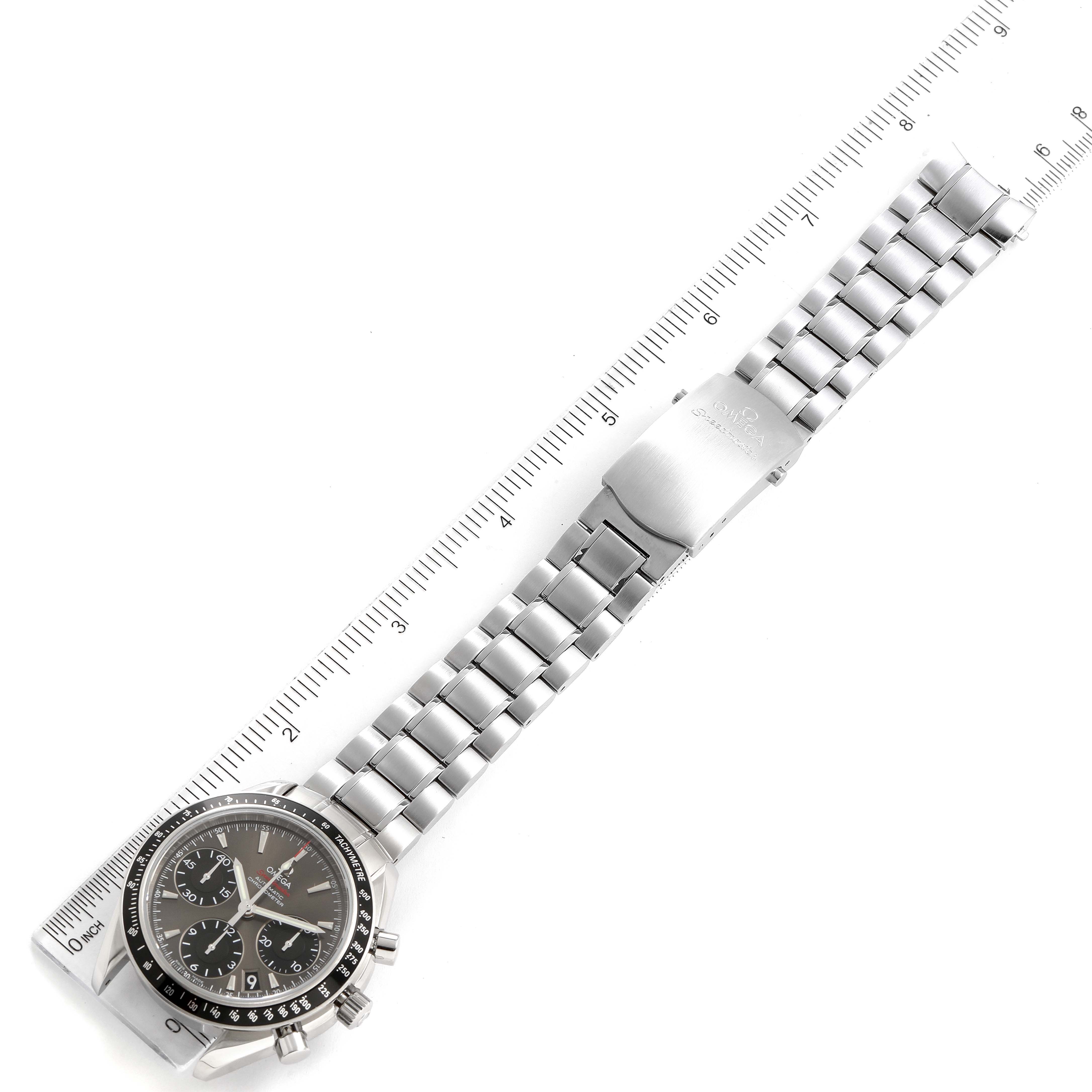 The Omega Speedmaster 323.30.40.40.06.001 Men's Stainless Steel Grey Dial 323.30.40.40.06.001 Men's Stainless Steel Grey Dial watch is shown flat with its metal band and clasp fully extended, alongside a ruler for measuring.