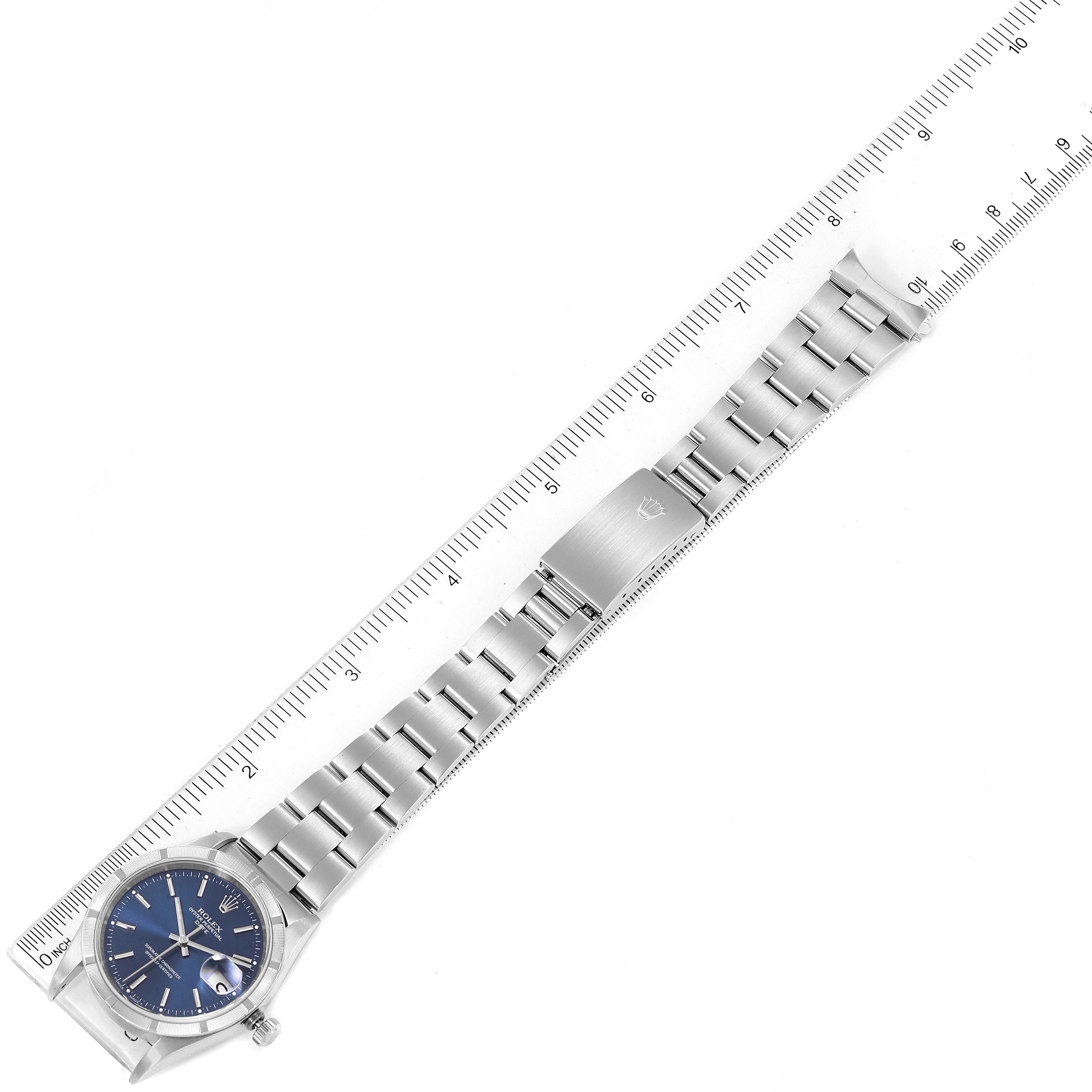 The image shows a stainless steel Rolex Date 15210 Men's Stainless Steel Blue Dial 15210 Men's Stainless Steel Blue Dial watch, displayed flat and measured against a ruler for scale.