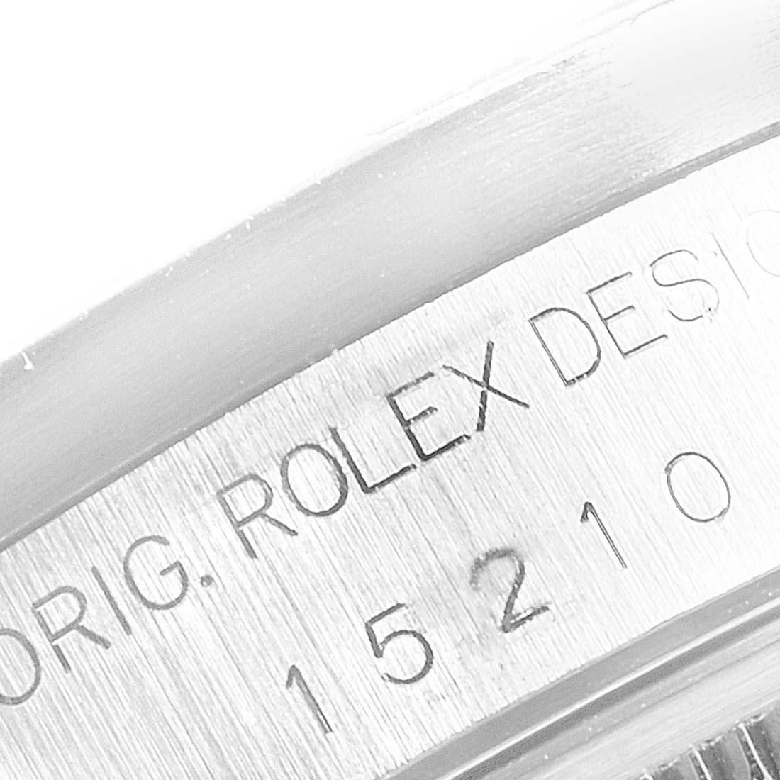 This close-up image shows part of the engraved case back of a Rolex Date 15210 Men's Stainless Steel Blue Dial 15210 Men's Stainless Steel Blue Dial model watch, featuring the brand name and model number.