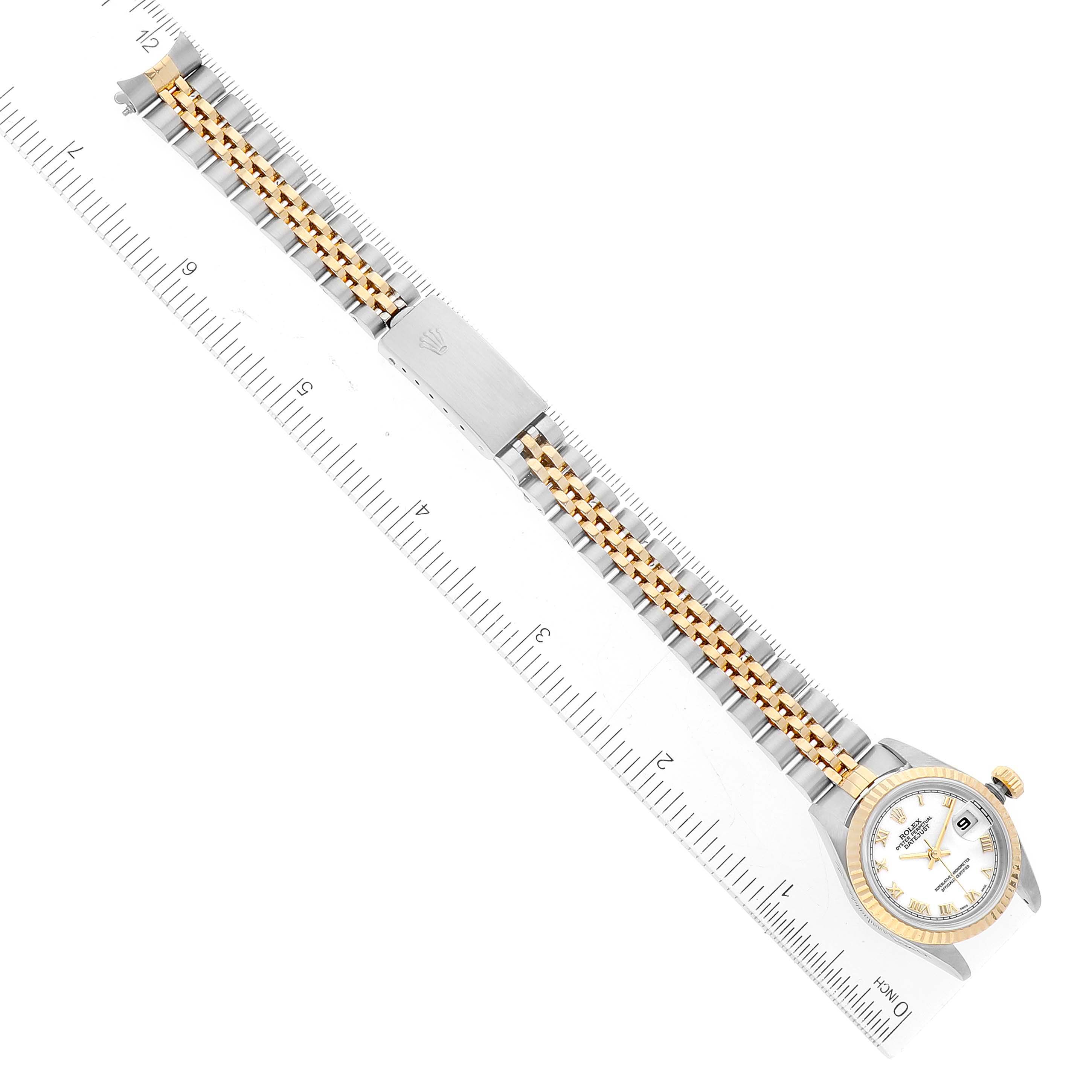 The image shows a top-down view of a Rolex Datejust 79173 Women's Steel and Gold (two tone) White Dial 79173 Women's Steel and Gold (two tone) White Dial watch, including the face and full bracelet, against a ruler for scale.