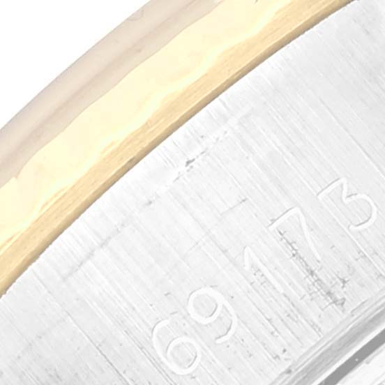 This close-up image shows a portion of the Rolex Datejust 69173 Women's Steel and Gold (two tone) Blue Dial 69173 Women's Steel and Gold (two tone) Blue Dial model's bezel and case with engraved model numbers.