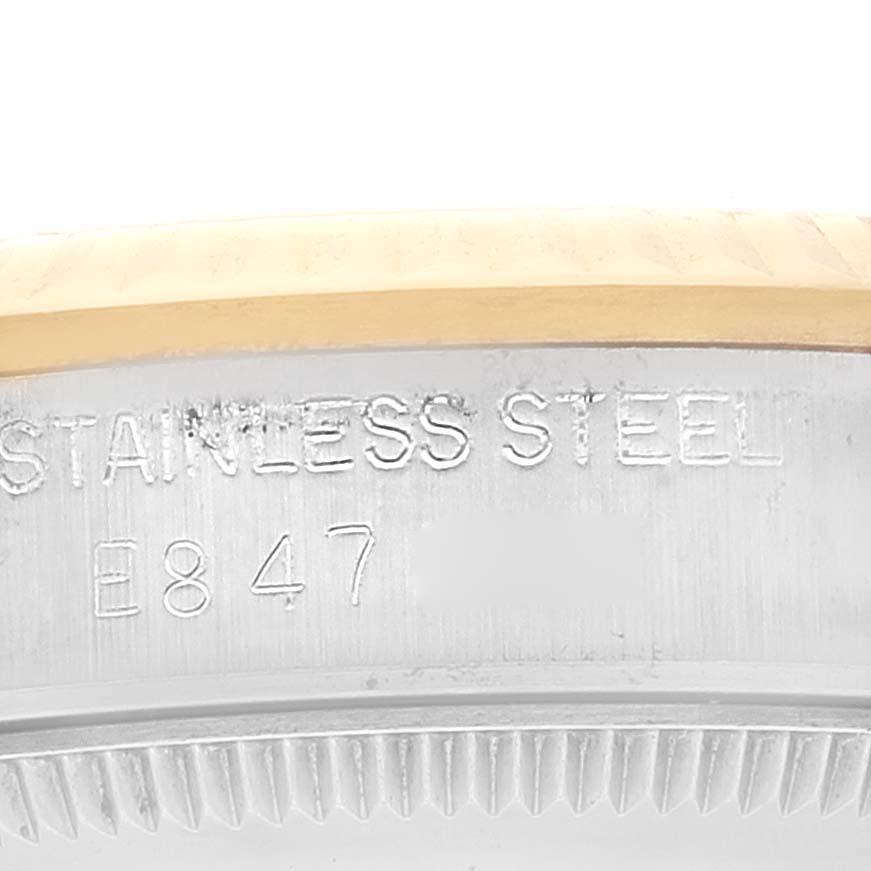 This close-up image shows the case back and edge of the bezel of a Mid-Size Rolex watch, highlighting the "Stainless Steel" inscription.