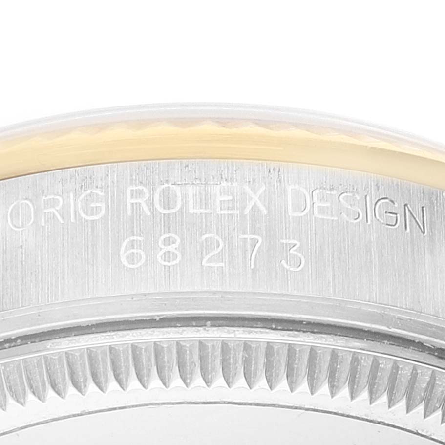 The image shows a close-up of the side engraving on a Rolex Mid-Size 68273 Women
s Steel and Gold (two tone) Champagne Dial 68273 Women
s Steel and Gold (two tone) Champagne Dial watch, displaying "ORIG ROLEX DESIGN" and the model number 68273.