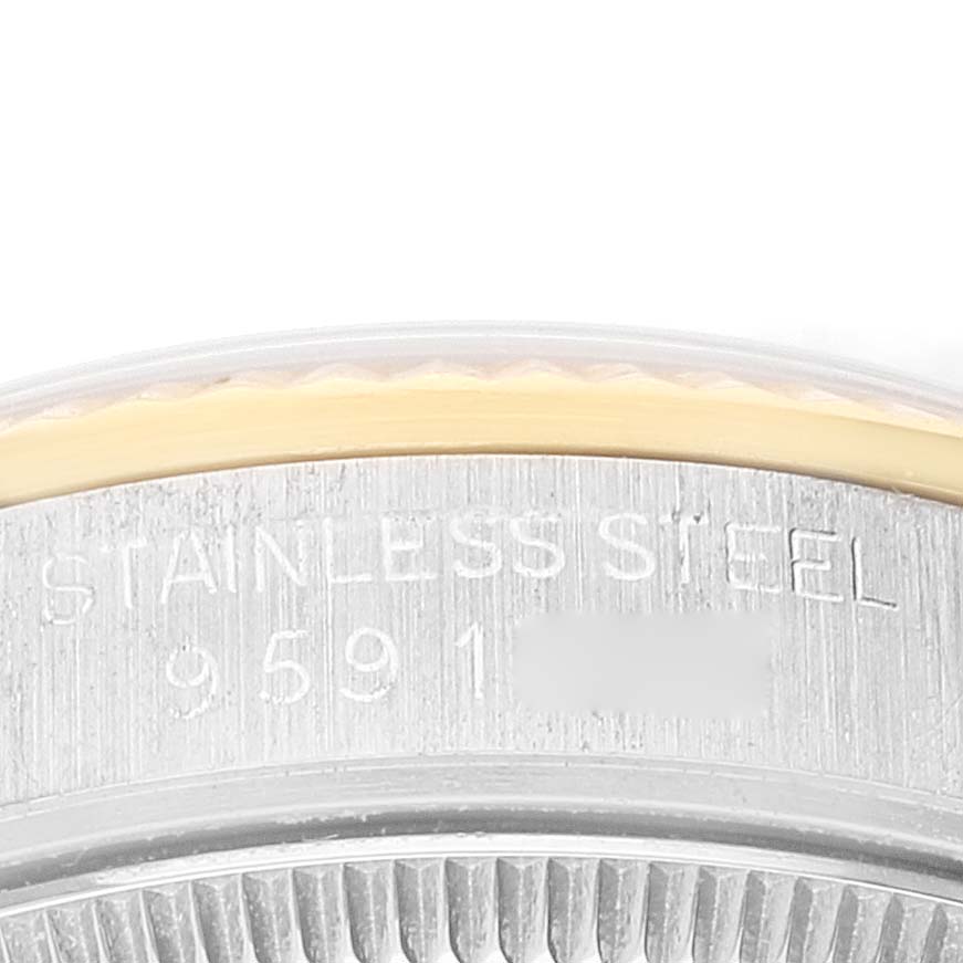The image shows a close-up of the bezel and side casing with engraved details of a Mid-Size Rolex watch in stainless steel.