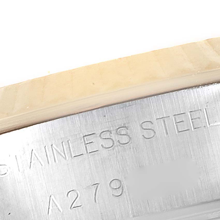 The image shows a close-up angle of the inner part of the bezel and case of a Rolex Datejust 79173 Women
s Steel and Gold (two tone) Black Dial 79173 Women
s Steel and Gold (two tone) Black Dial watch, displaying part of the serial number and "STAINLESS STEEL" engraving.