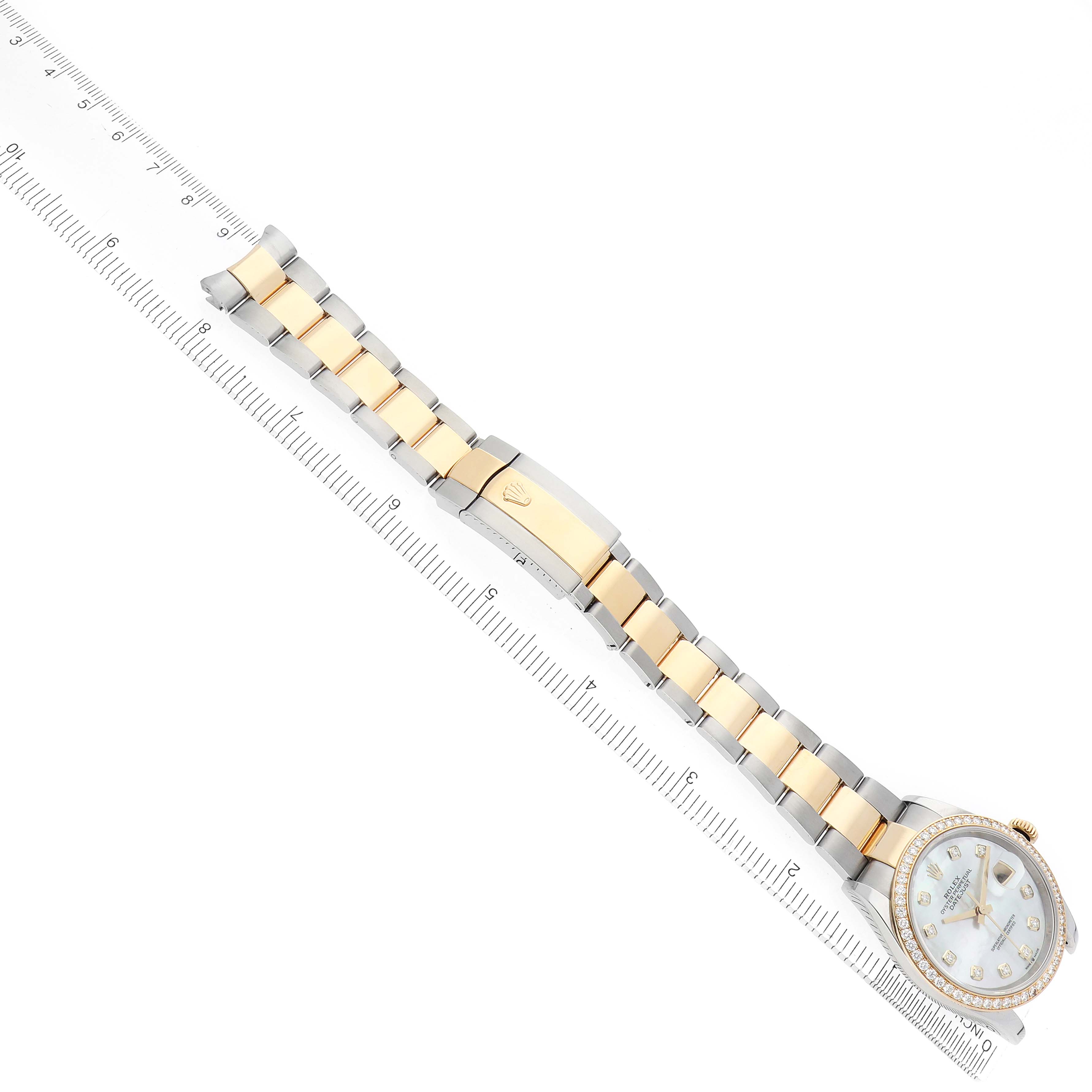 The image shows a Rolex Datejust 126283 Men's Steel and Gold (two tone) Mother of Pearl Dial watch at a diagonal angle with focus on the bracelet and clasp, alongside a ruler for scale.