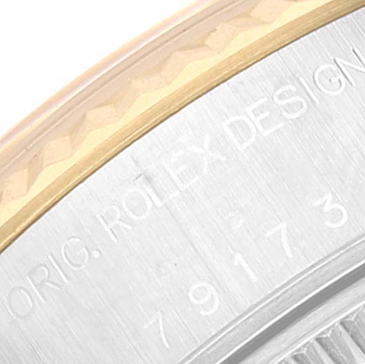 This close-up image shows the case back and edge inscriptions of the Rolex Datejust 79173 Women's Steel and Gold (two tone) Beige Dial 79173 Women's Steel and Gold (two tone) Beige Dial watch.