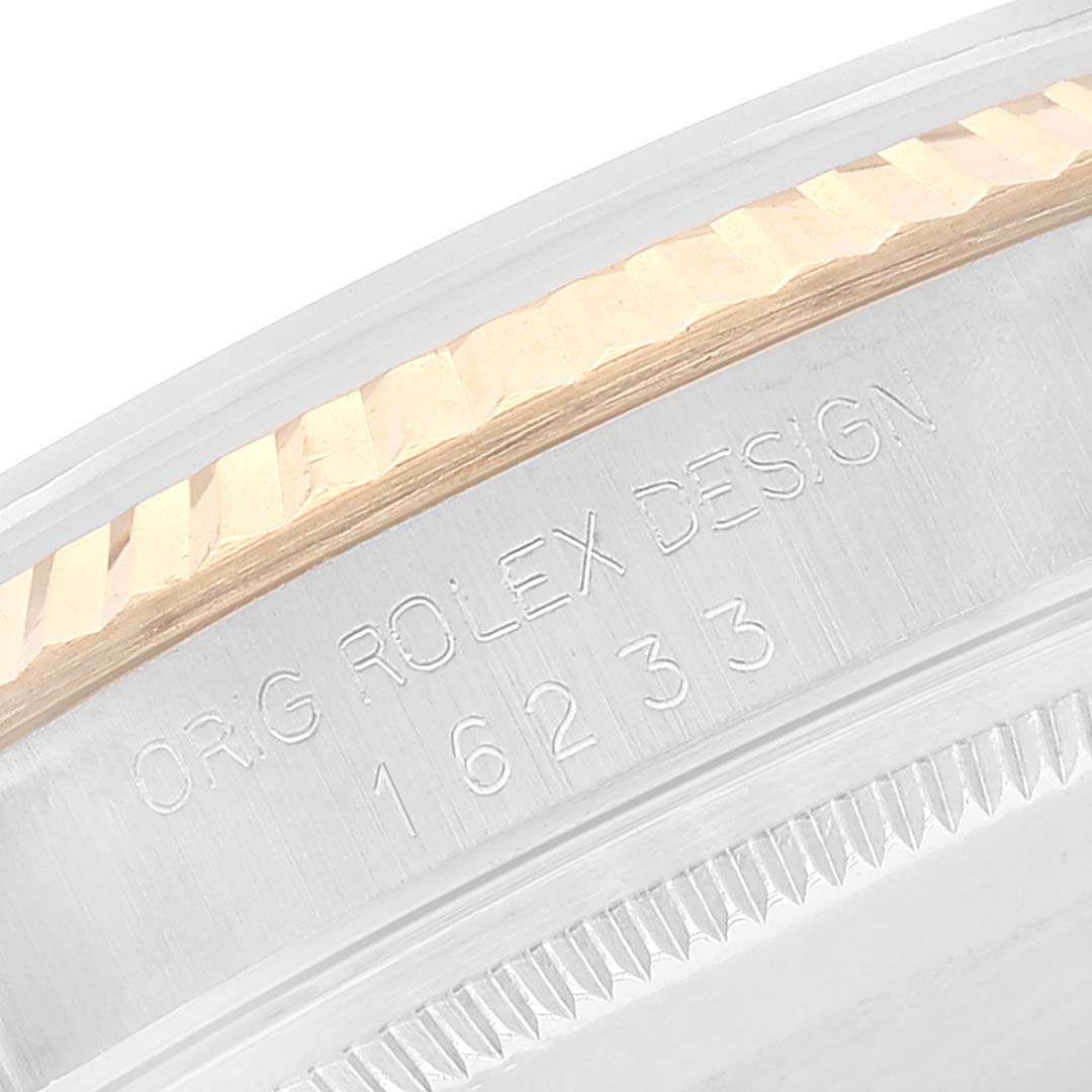 The image shows the side edge of a Rolex Datejust 16233 Men's Steel and Gold (two tone) White Dial 16233 Men's Steel and Gold (two tone) White Dial watch, highlighting its fluted bezel and engraved model number.