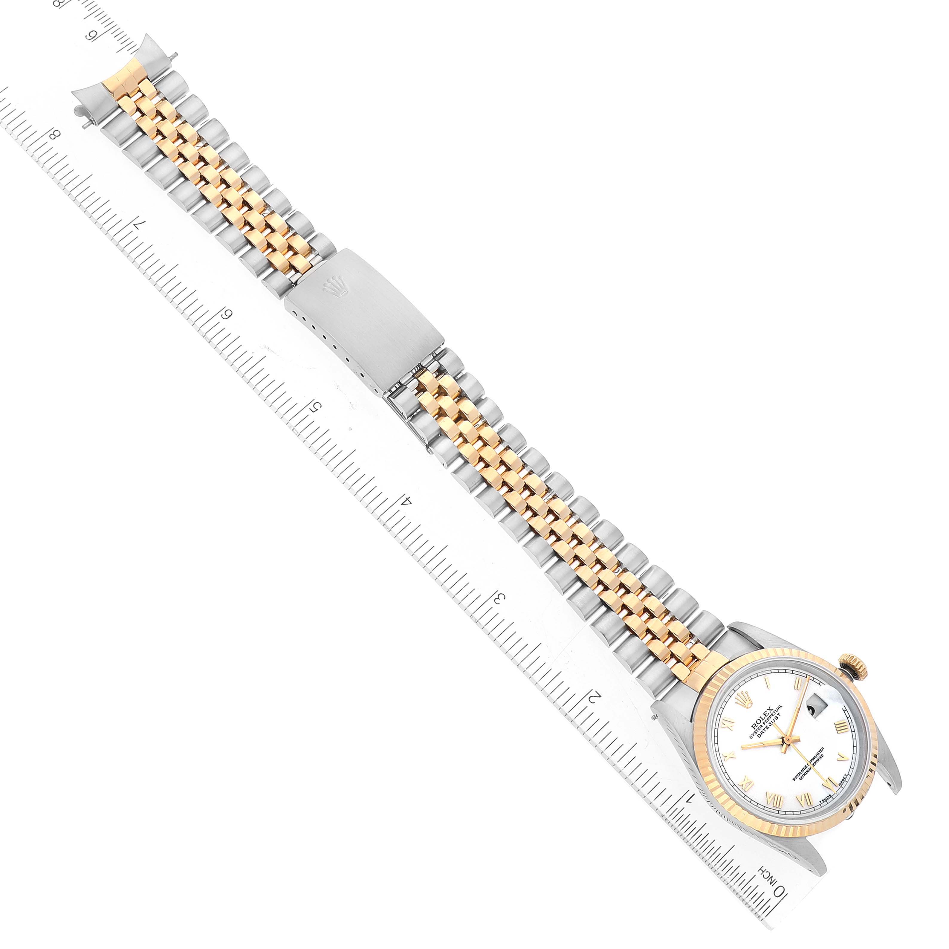 The image shows a Rolex Datejust 16233 Men's Steel and Gold (two tone) White Dial 16233 Men's Steel and Gold (two tone) White Dial watch from a top-down view, highlighting the face, two-tone bracelet, and clasp, with a ruler for scale.