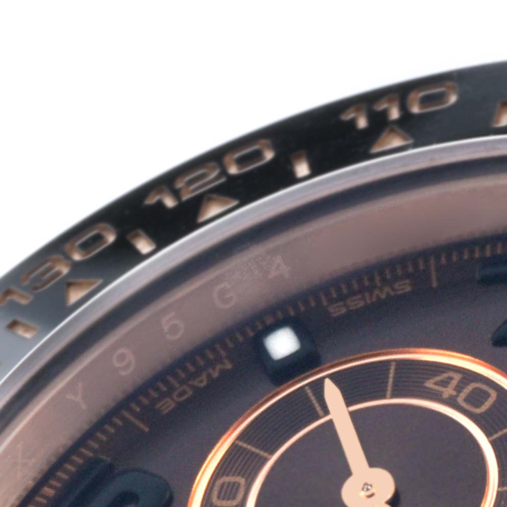 The image shows a close-up of the bezel and part of the dial of a Rolex Daytona 116515LN Men
s Rose Gold Brown Dial watch, highlighting the tachymetric scale.