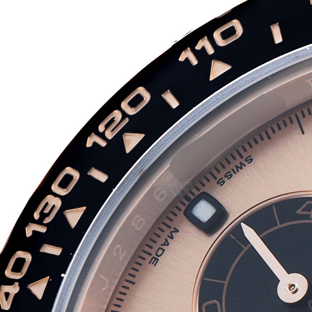 The image shows a close-up of a Rolex Daytona 116515LN Men
s Rose Gold Pink Dial
s bezel and part of the dial with a focus on the numeric markers.