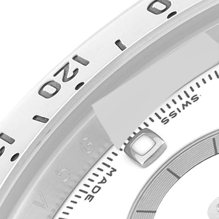 The image shows a close-up of the bezel and part of the dial of a Rolex Daytona 116520 Men
s Stainless Steel White Dial 116520 Men
s Stainless Steel White Dial watch.