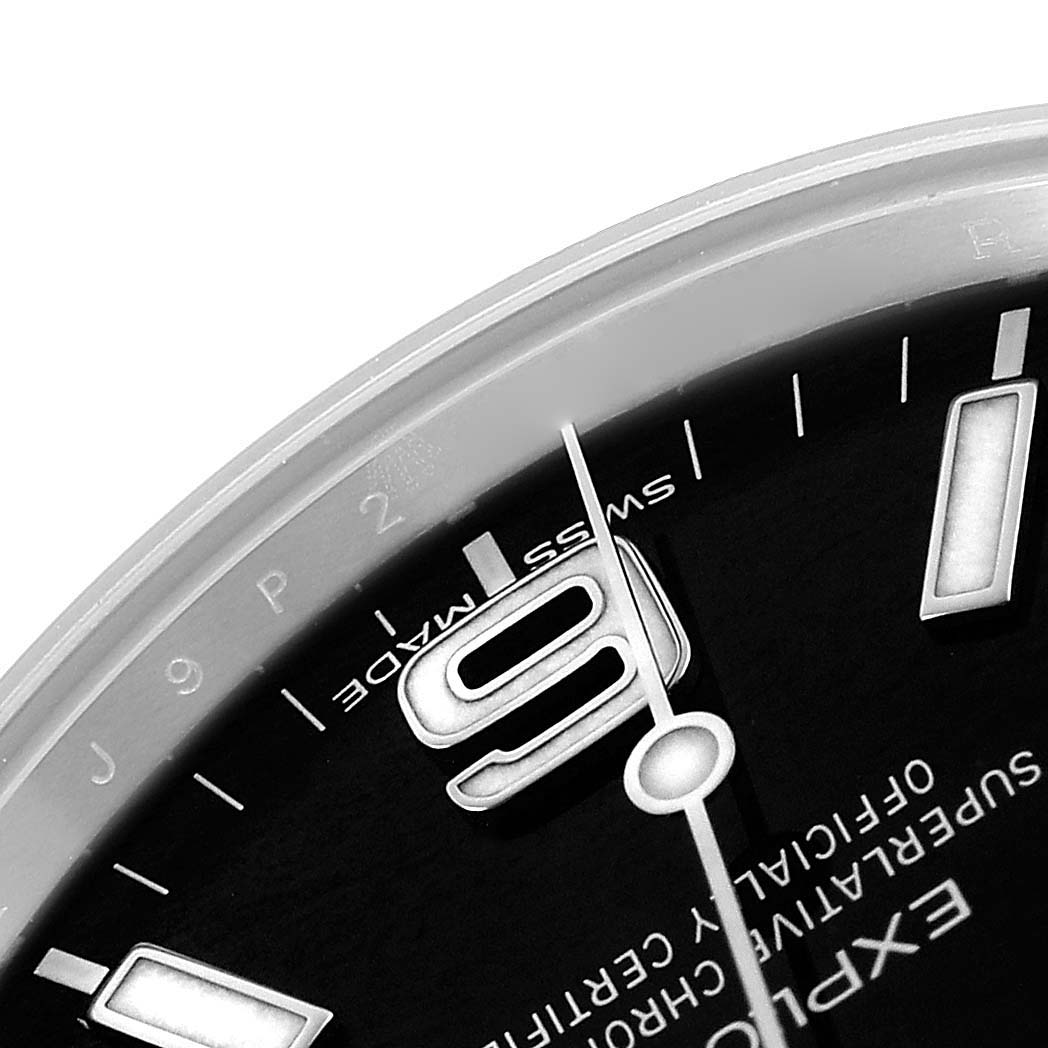 The image shows a close-up of the Rolex Explorer 214270 Men's Stainless Steel Black Dial's dial, focusing on the 9 o'clock marker, hands, and part of the branding.
