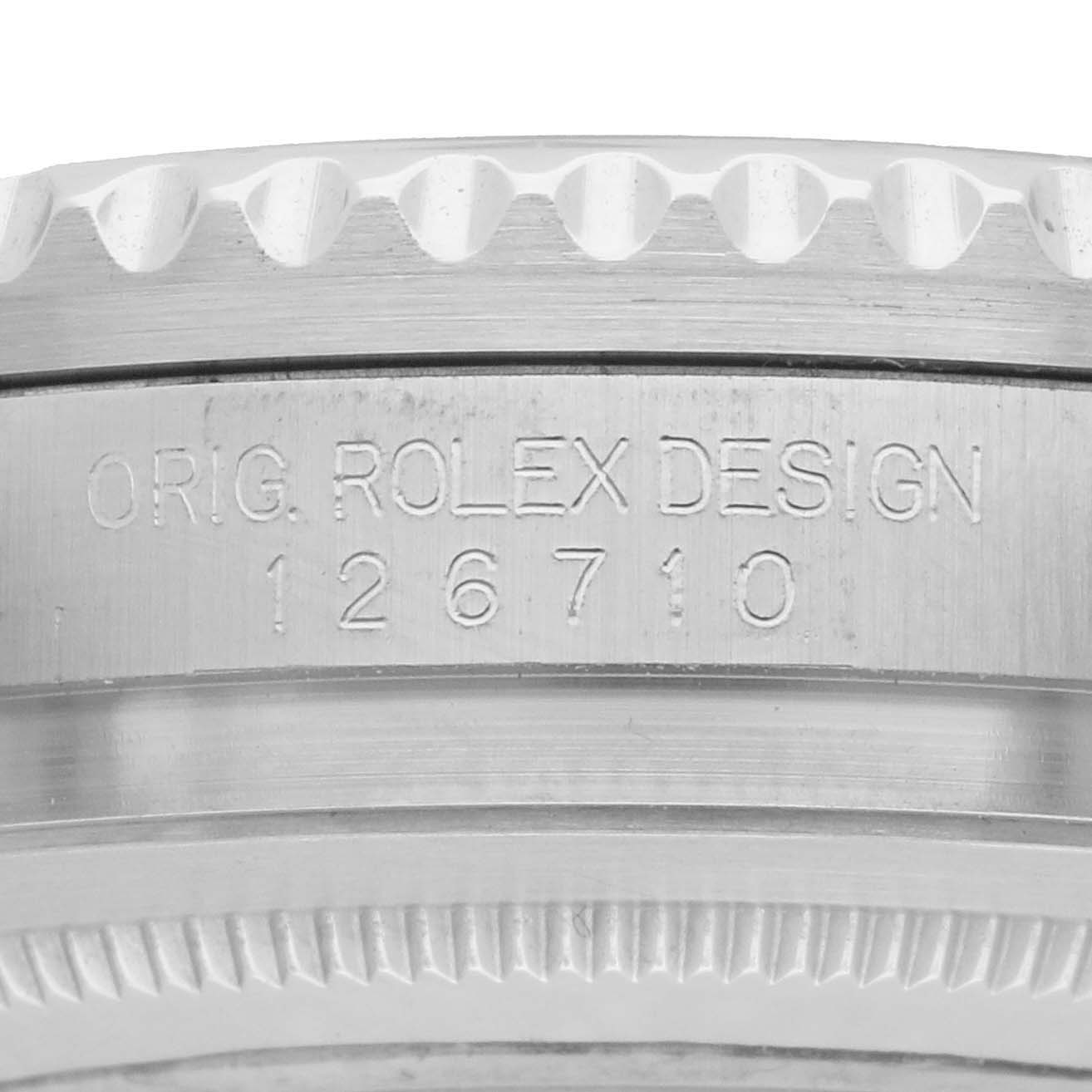 The image shows a close-up view of the edge and serial engravings on a Rolex GMT-Master 126710 Men's Stainless Steel Black Dial watch case.